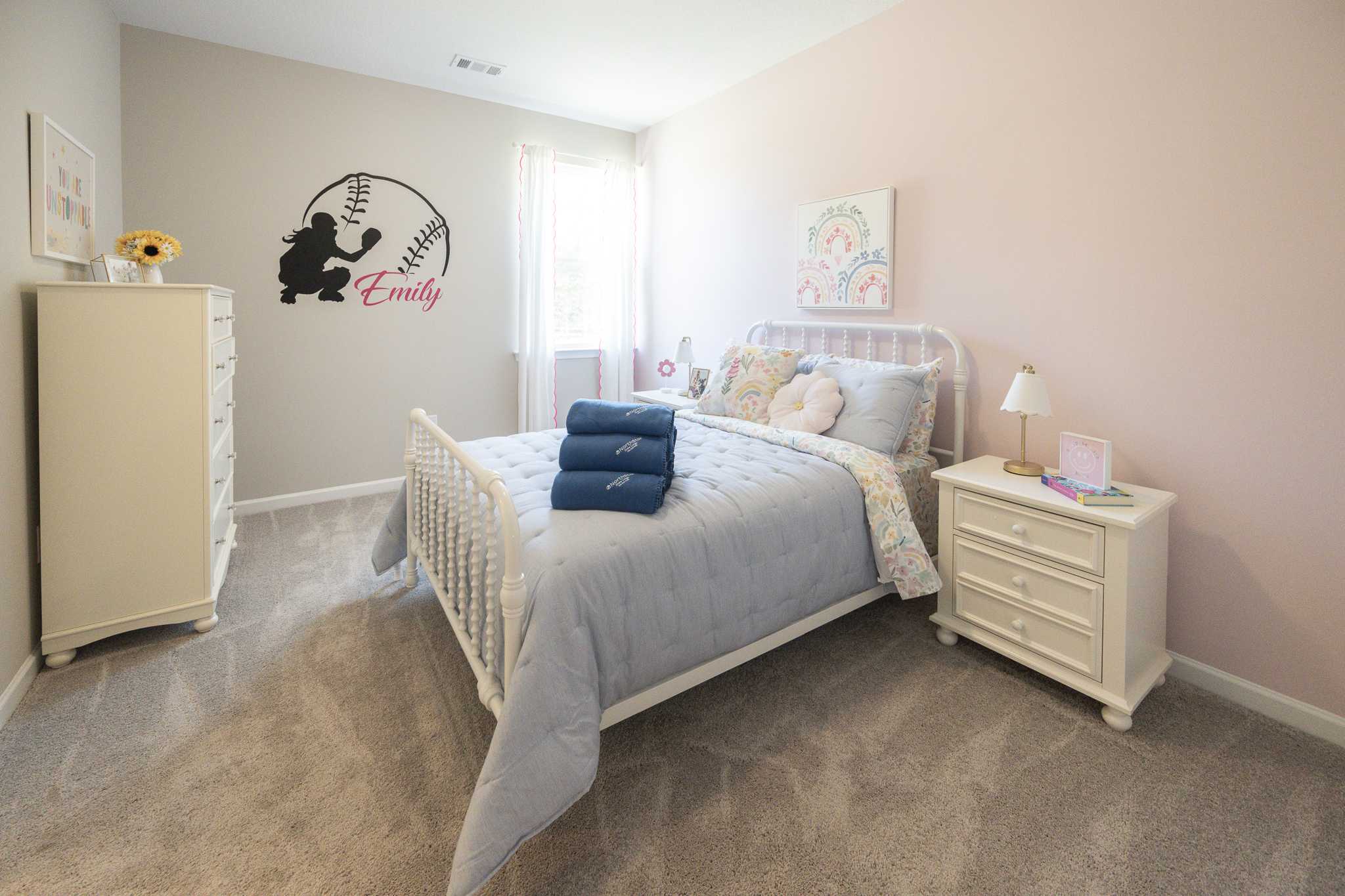 Baseball-themed girl's bedroom at Silver Oak in Cusseta Alabama by Evermore Homes with pink walls, white bed, and Emily bat silhouette