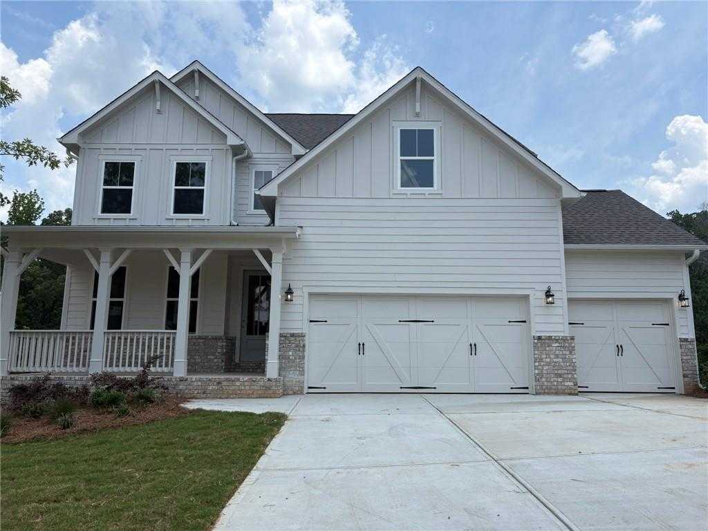Two-story white Craftsman home with wraparound porch, 3-car garage, and brick accents in Riverwood, Dallas, Georgia