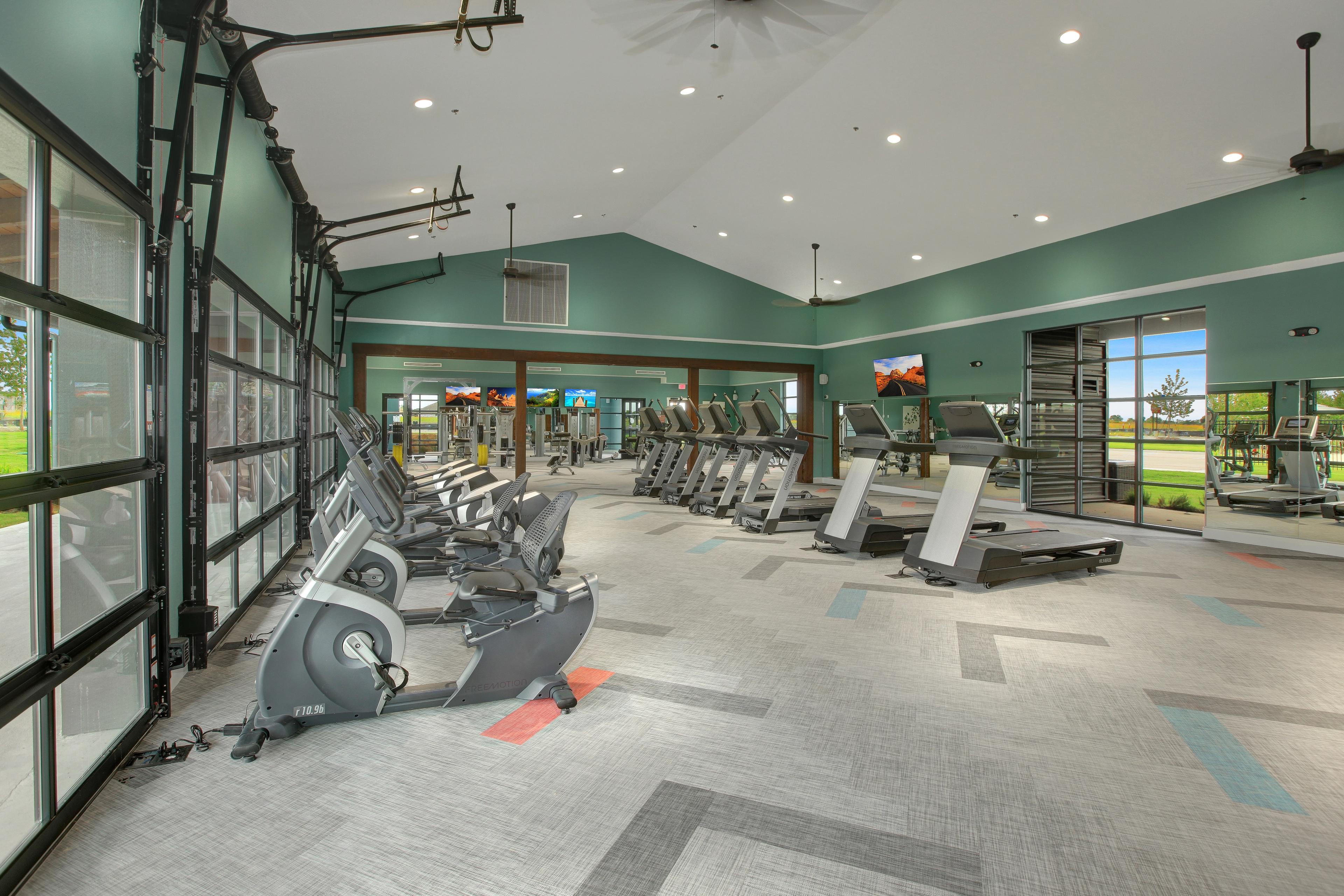 Onsite workout gym with treadmills, weight machines and televisions