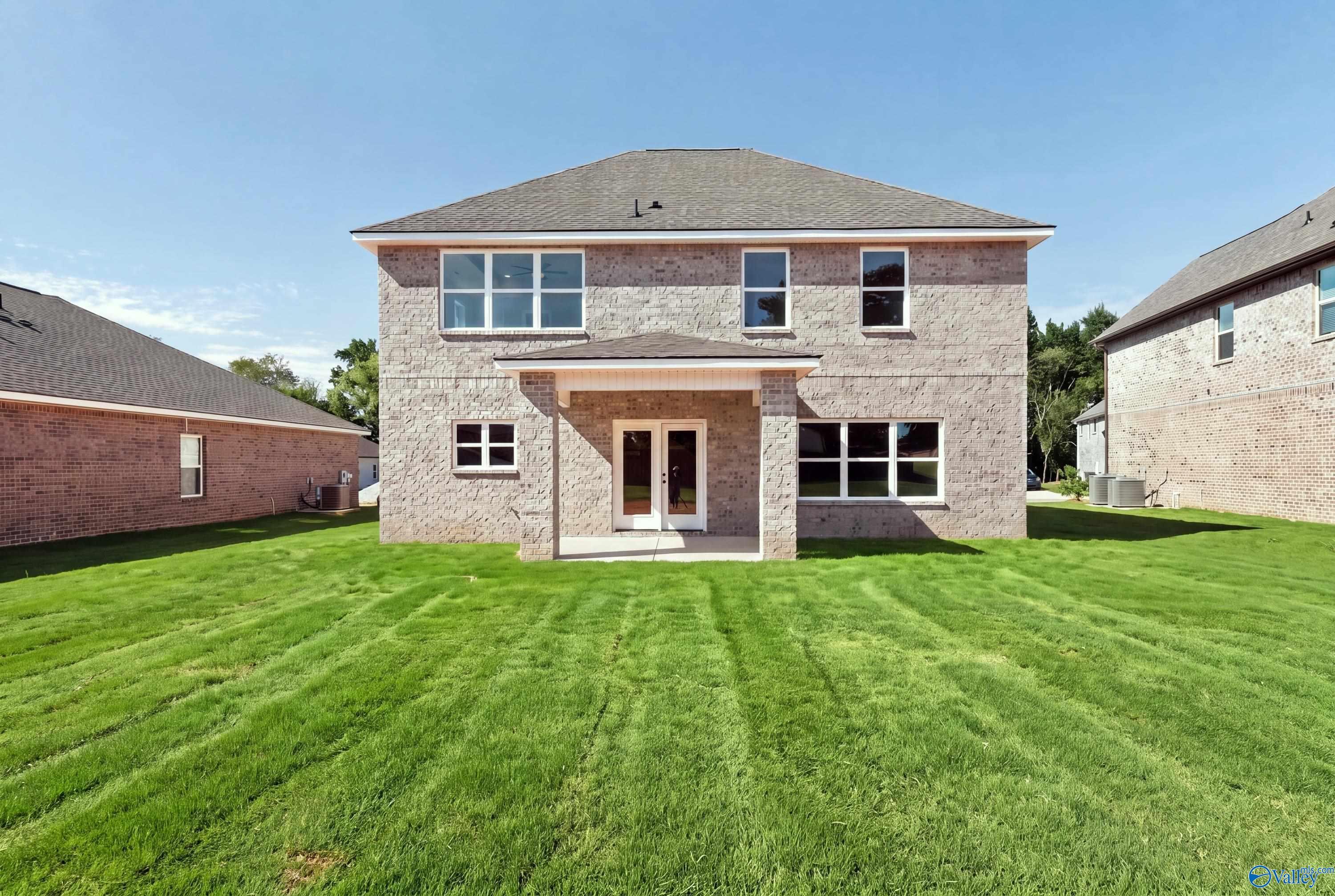 Two-story brick home with covered patio overlooking spacious fenced backyard in Creek Grove, New Market, Alabama by Davidson Homes