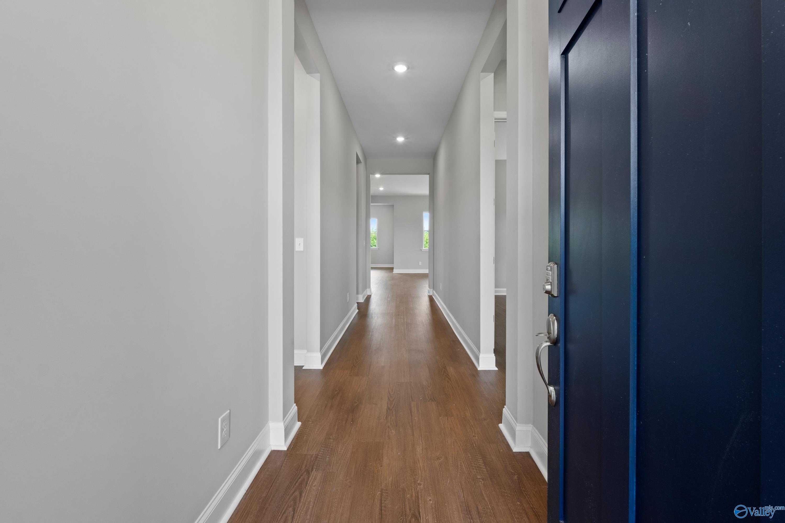 Long hallway with hardwood floors, gray walls, and recessed lighting in The Arcadia 4-bedroom home, Huntsville, Alabama