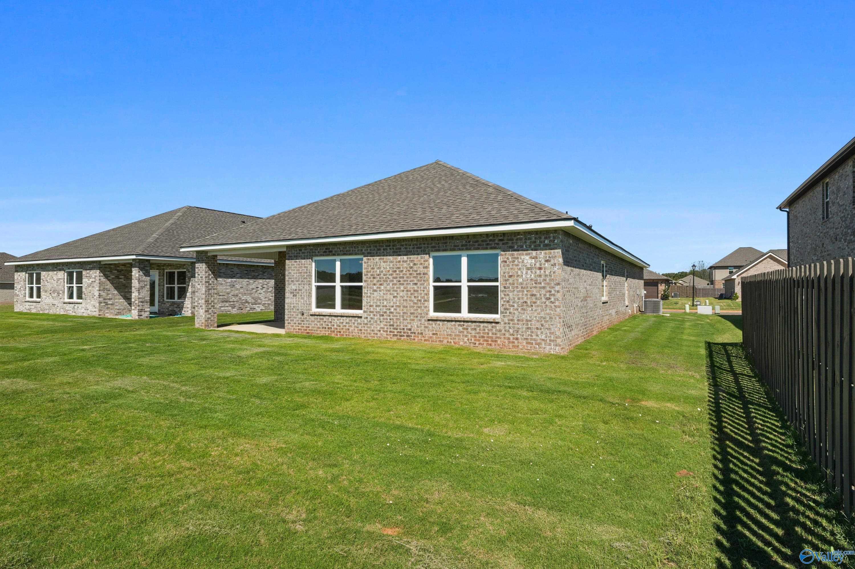 Single-story brick home with 2-car garage, large windows, and gabled roof on lush green lawn in Clearview, Hazel Green, Alabama - Davidson Homes The Everett