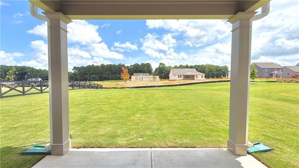 Covered back patio view overlooking a large private backyard in Wehunt Meadows, Hoschton, Georgia by Davidson Homes.