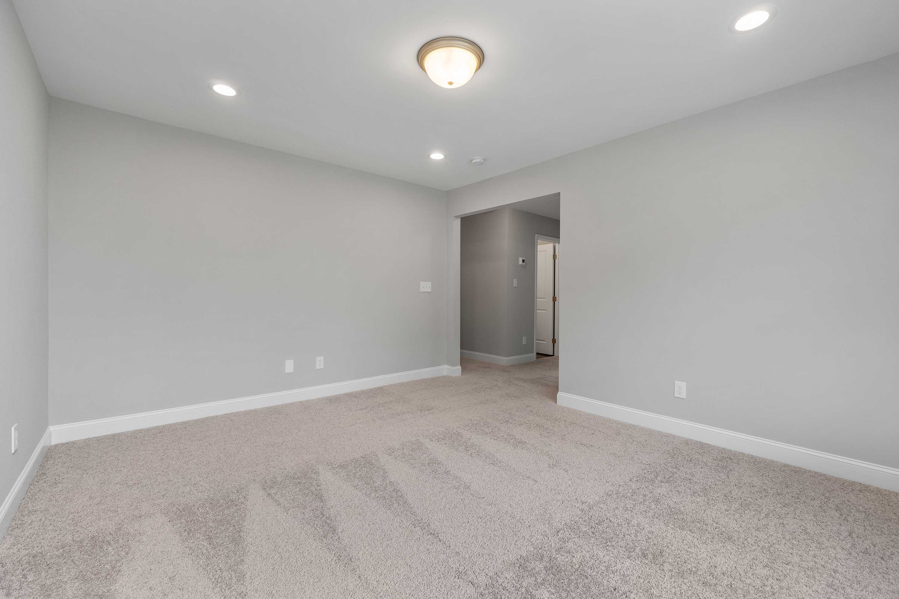 Spacious empty bonus room in The Aiken by Davidson Homes with gray walls, beige carpet, recessed lights