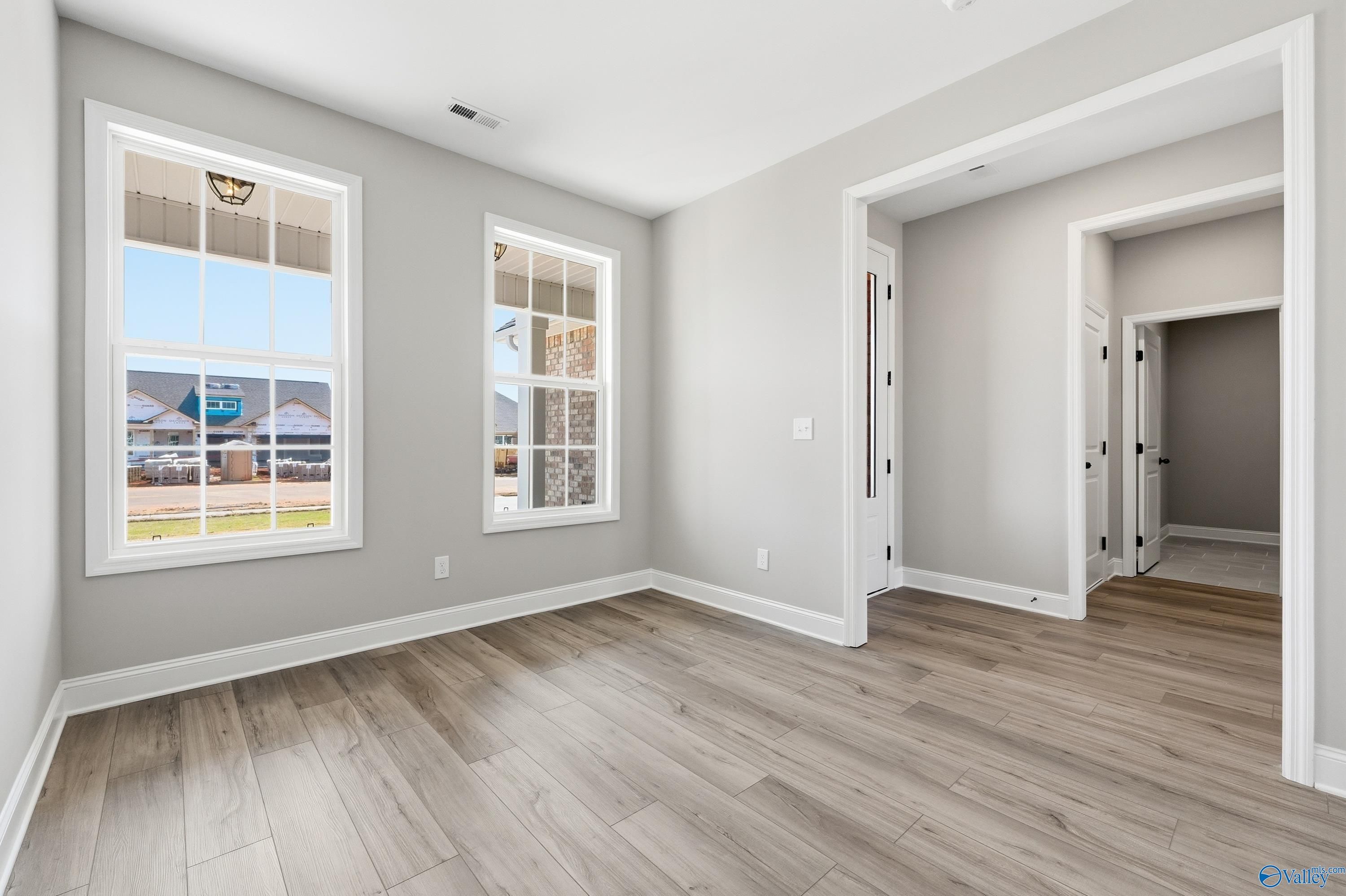 Bright secondary bedroom with large windows overlooking green lawn in Davidson Homes The Rockford, Creekside, Harvest, Alabama