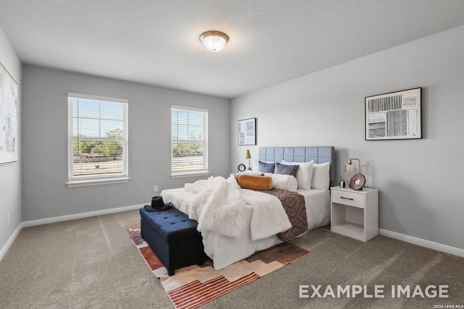 Cozy bedroom with blue upholstered headboard in The Gillian A floor plan by Davidson Homes in Cedar Heights, San Antonio.