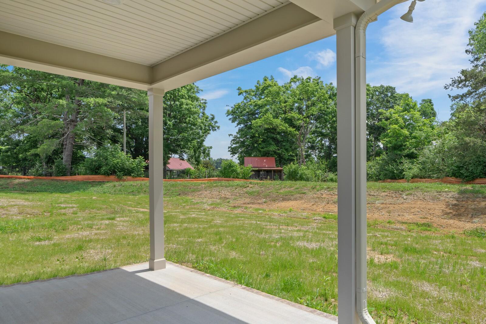 Covered patio view of a large backyard in Woods Crossing, Gallatin, TN, featuring The Ridgeport C floor plan.