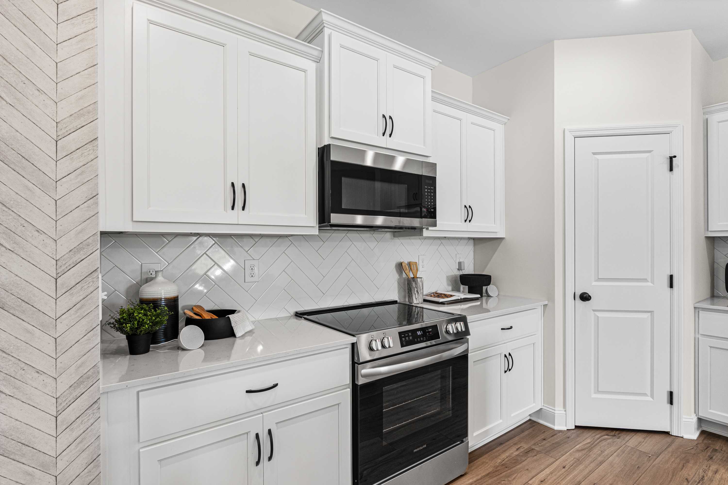Bright kitchen with white shaker cabinets, stainless steel appliances, subway tile backsplash, shiplap wall in Lynn Meadows Meridianville AL