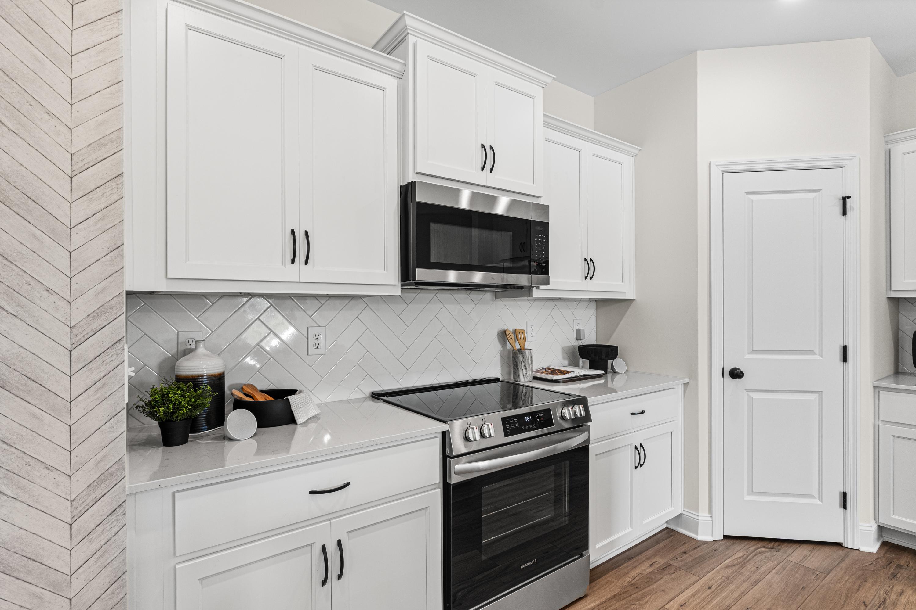 Bright kitchen with white shaker cabinets, stainless steel appliances, subway tile backsplash, shiplap wall in Lynn Meadows Meridianville AL