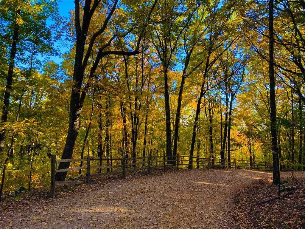 Autumn gravel path winding through vibrant yellow-orange trees and wooden rail fence in The Village at Shallowford, Kennesaw, Georgia