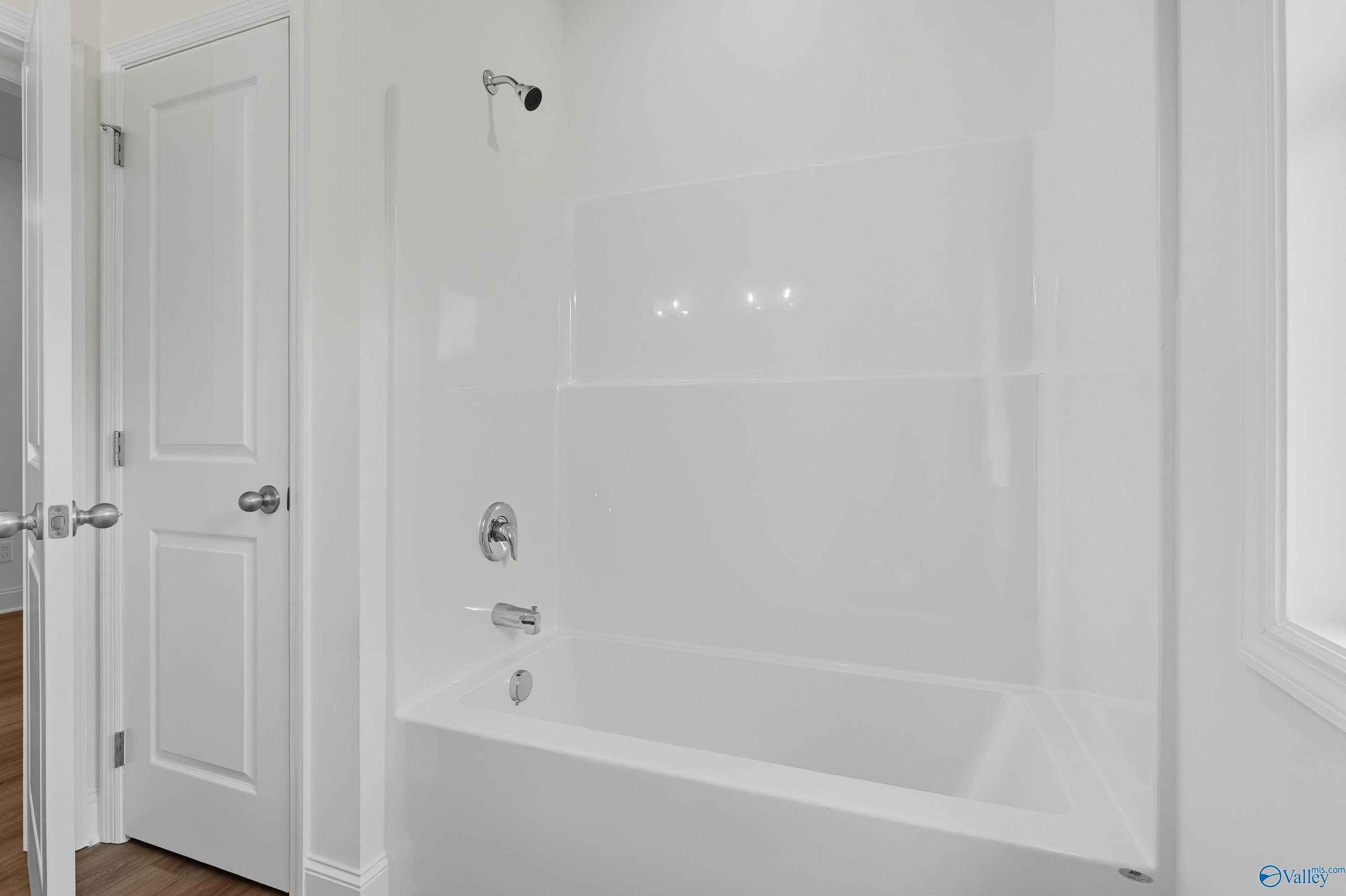 Modern white bathroom with soaking tub, walk-in shower, and sleek fixtures in 4-bedroom Davidson Homes The Everett, Meridianville AL