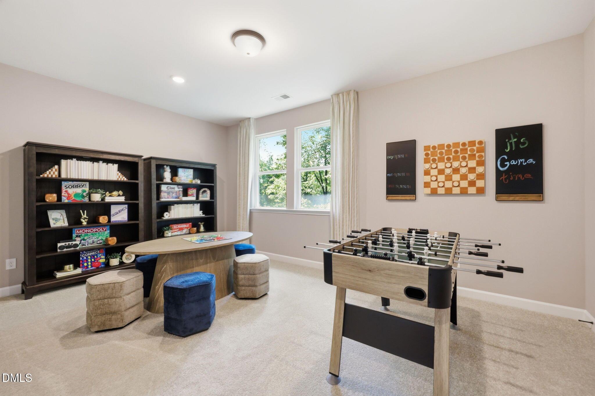 Spacious game room with foosball table and activity area in The Aspen B floor plan at Wendell Ridge, Wendell, NC.