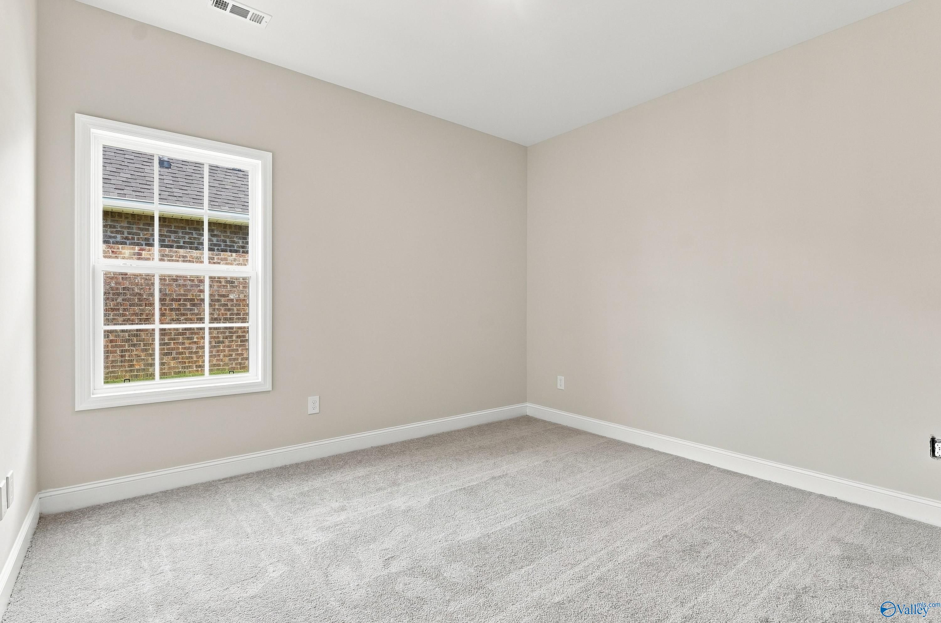 Bright, neutral-toned bedroom with plush carpeting in The Rockford B floor plan at Kendall Downs, Toney, Alabama.
