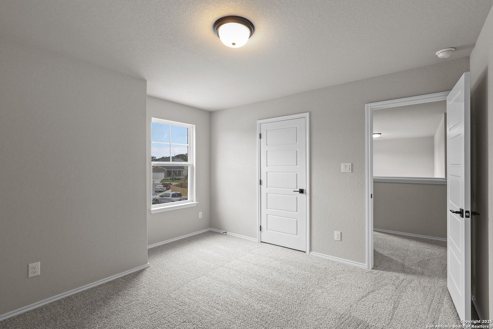 Bright secondary bedroom with gray walls, plush carpet, white doors, and window in Davidson Homes The Murray J, San Antonio