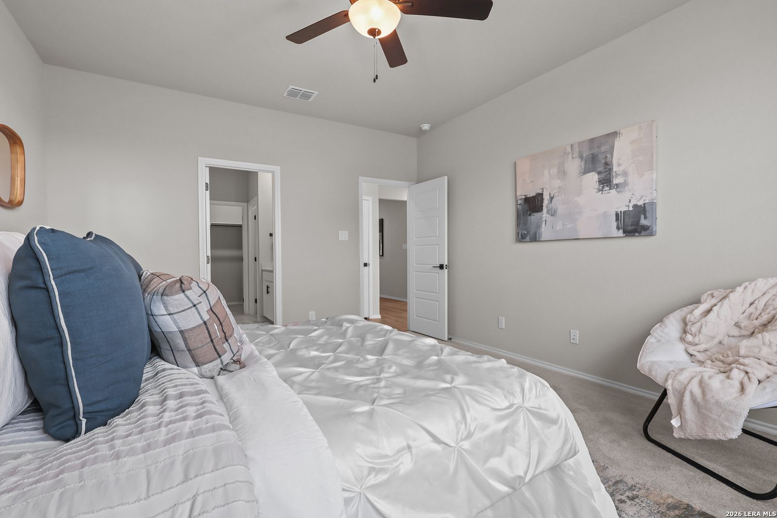 Spacious secondary bedroom with ceiling fan and walk-in closet in The Daphne H home at Hannah Heights, Seguin, Texas.