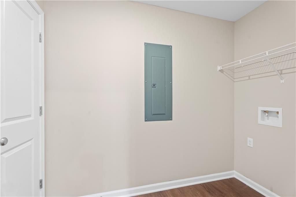 Functional laundry room featuring utility sink, electrical panel, and wire shelving in The Washington floor plan by Davidson Homes, Phenix City, Alabama