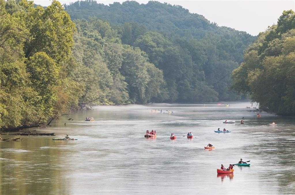 Serene river kayaking and canoeing amid lush green forests and rolling hills near Kennesaw, Georgia