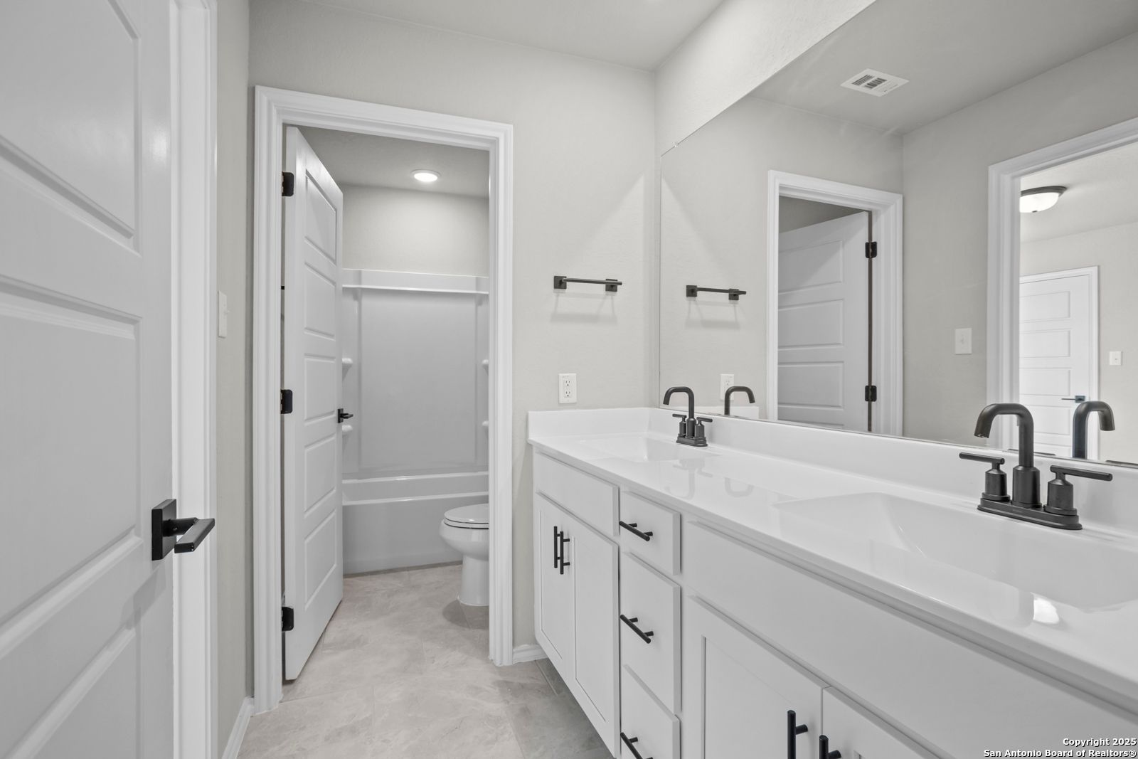 Elegant master bathroom with double vanity, soaking tub, and tile floors in Davidson Homes Sequoia A, Converse, Texas