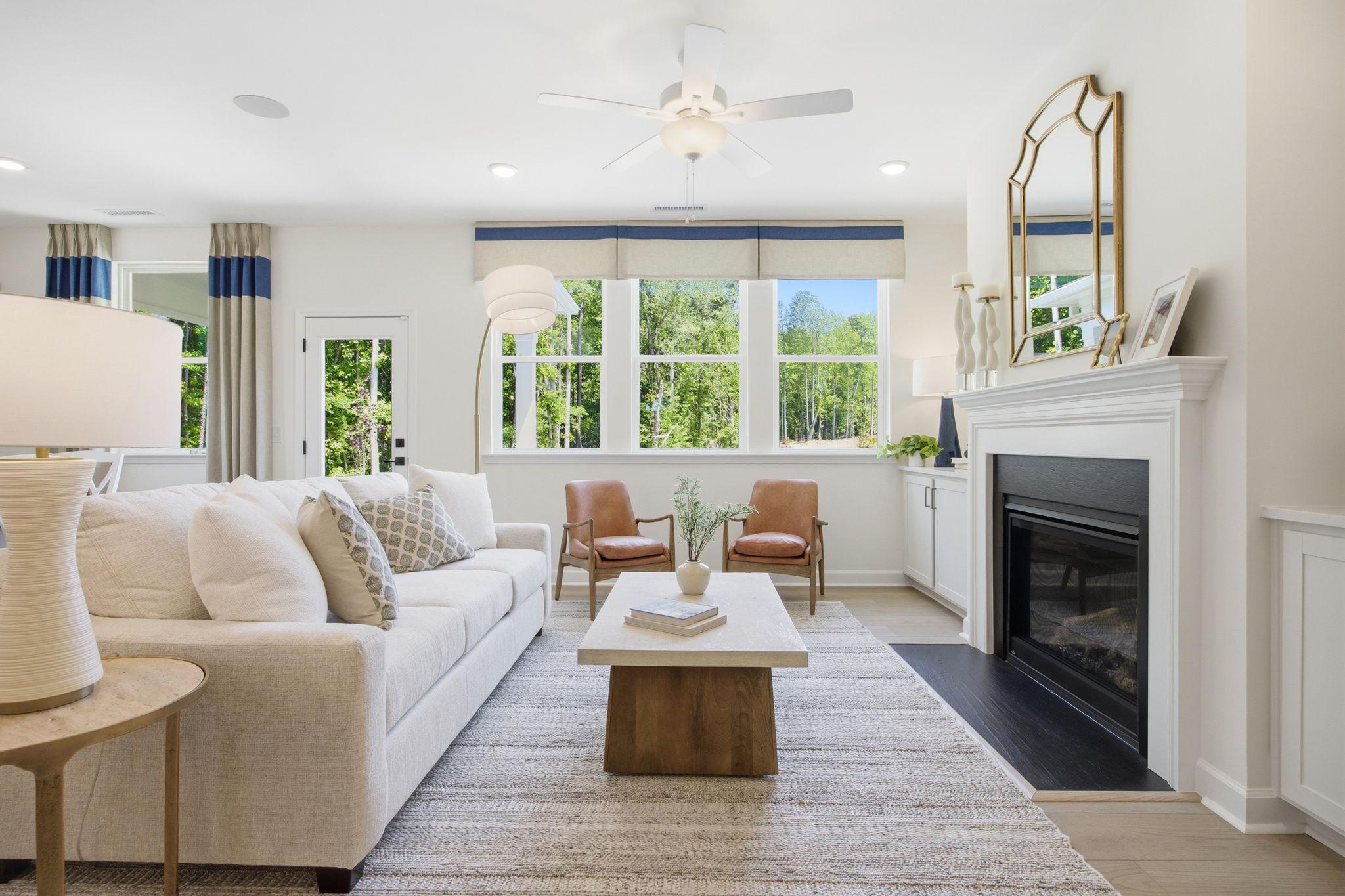 Bright, open-concept living room in The Ashport K featuring a fireplace, modern furniture, and natural light.
