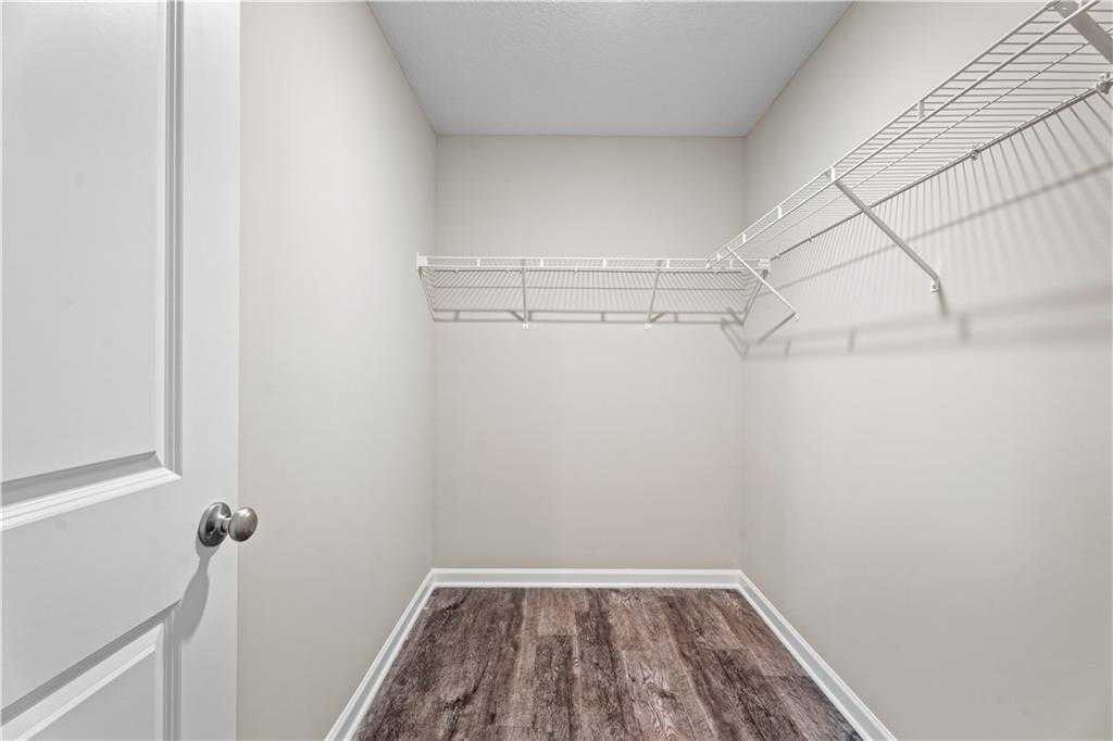 Spacious walk-in closet with wire shelving and hardwood floors in Davidson Homes The Washington, Phenix City, Alabama