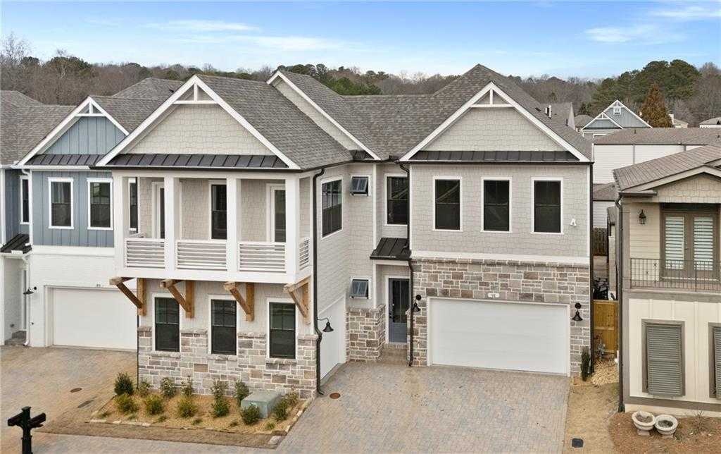 Modern 2-story stone and siding home with balcony, 3-car garage in The Village at Towne Lake, Woodstock, Georgia by Davidson Homes Seaside B