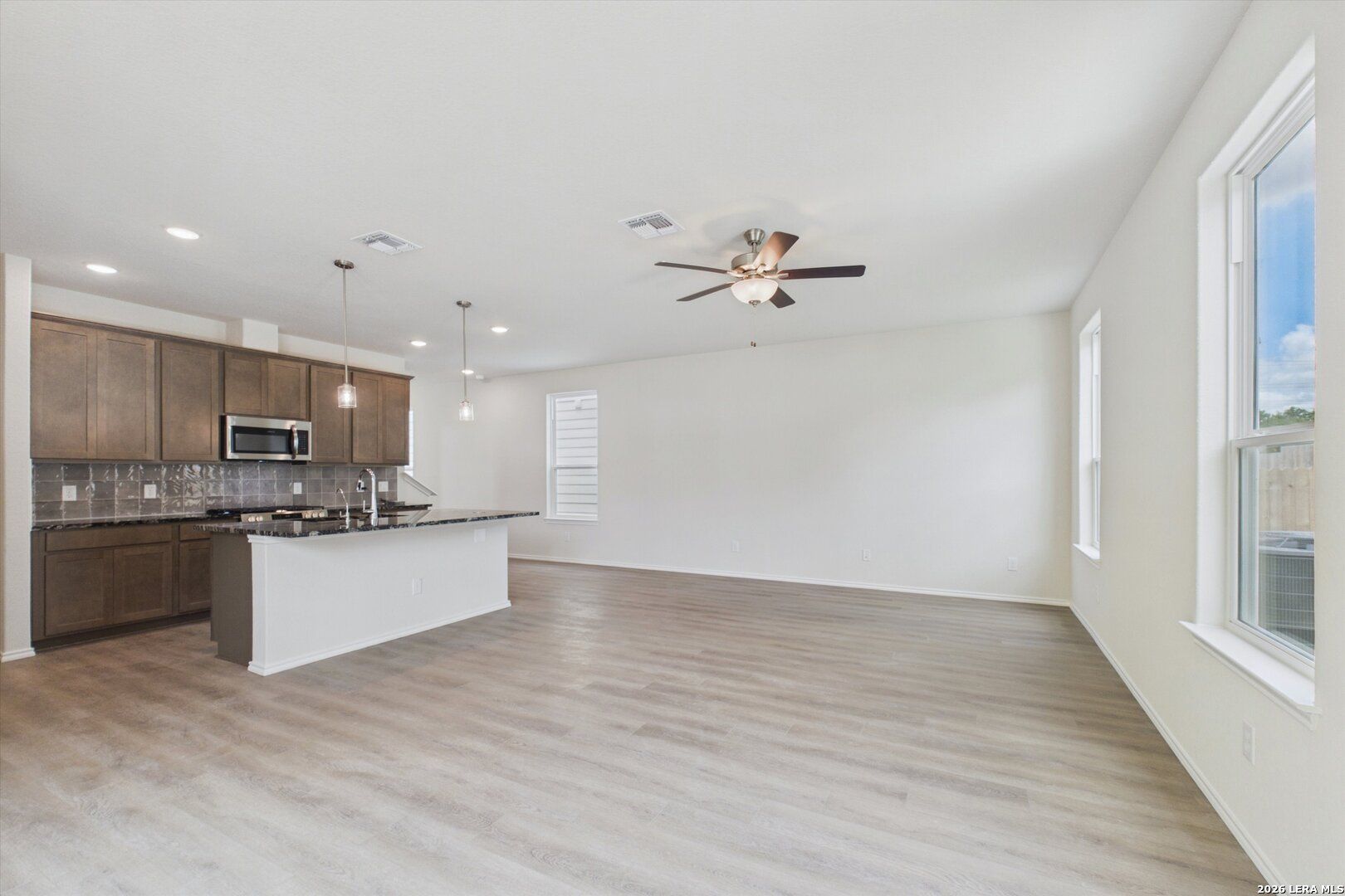 Open-concept kitchen and living area in The Charlotte B floor plan at Meadows at Oak Creek, San Antonio, Texas.