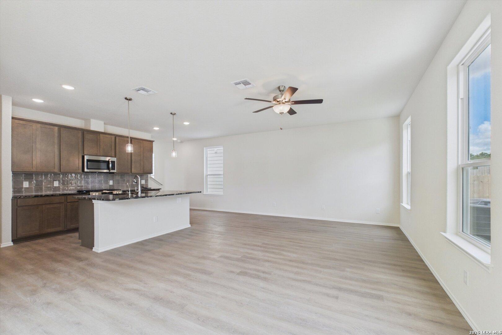 Open-concept kitchen and living area in The Charlotte B floor plan at Meadows at Oak Creek, San Antonio, Texas.