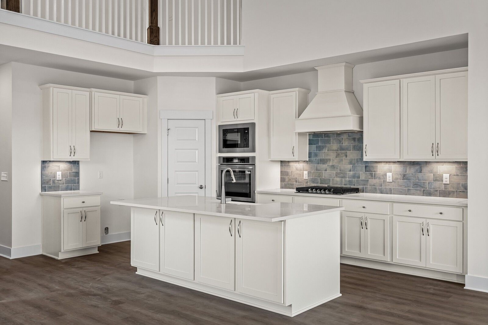 Modern white shaker kitchen with quartz island, stainless double ovens, blue subway tile backsplash in Ridgeport D, Mt. Juliet, TN