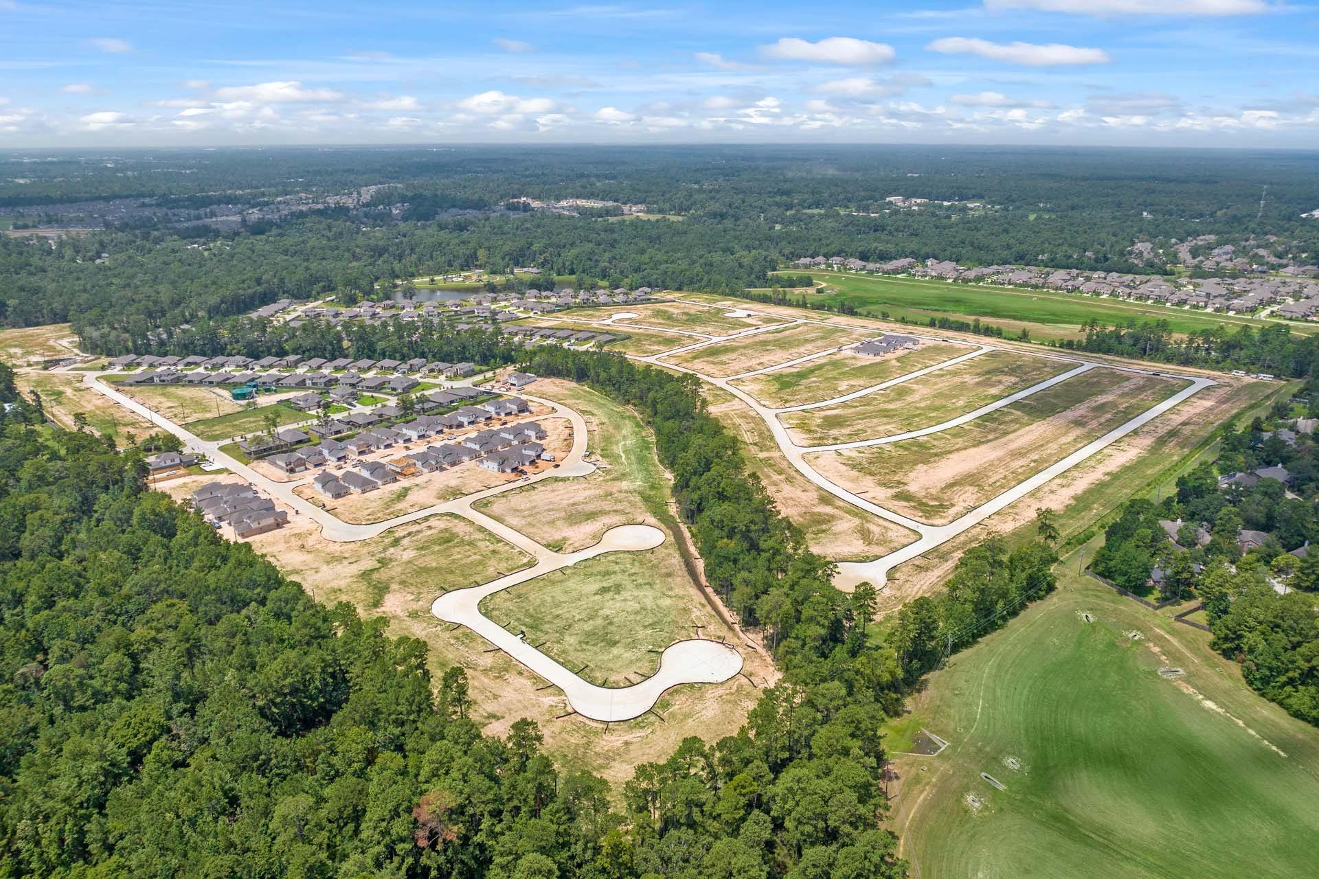 Aerial view of developing new homes and wooded lots at Lakes at Black Oak community in Magnolia Texas