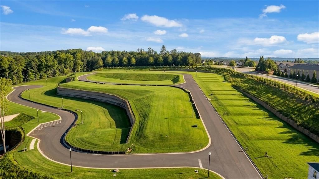 Aerial view of winding landscaped roads and lush green lawns in The Bluffs, Canton, Georgia, Davidson Homes community