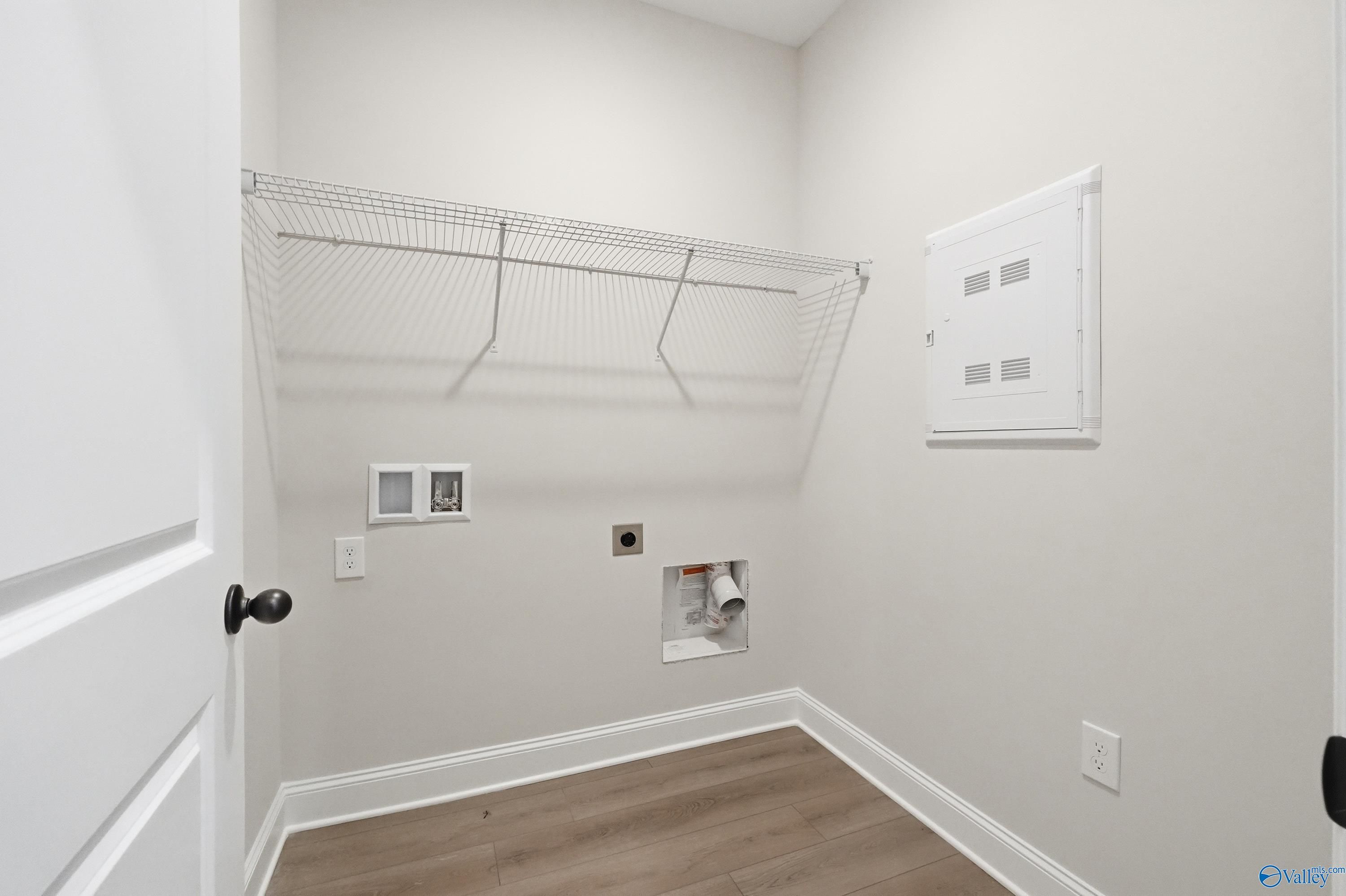 Functional laundry room with wire shelving, washer/dryer hookups, electrical panel in The Franklin home, Huntsville, Alabama