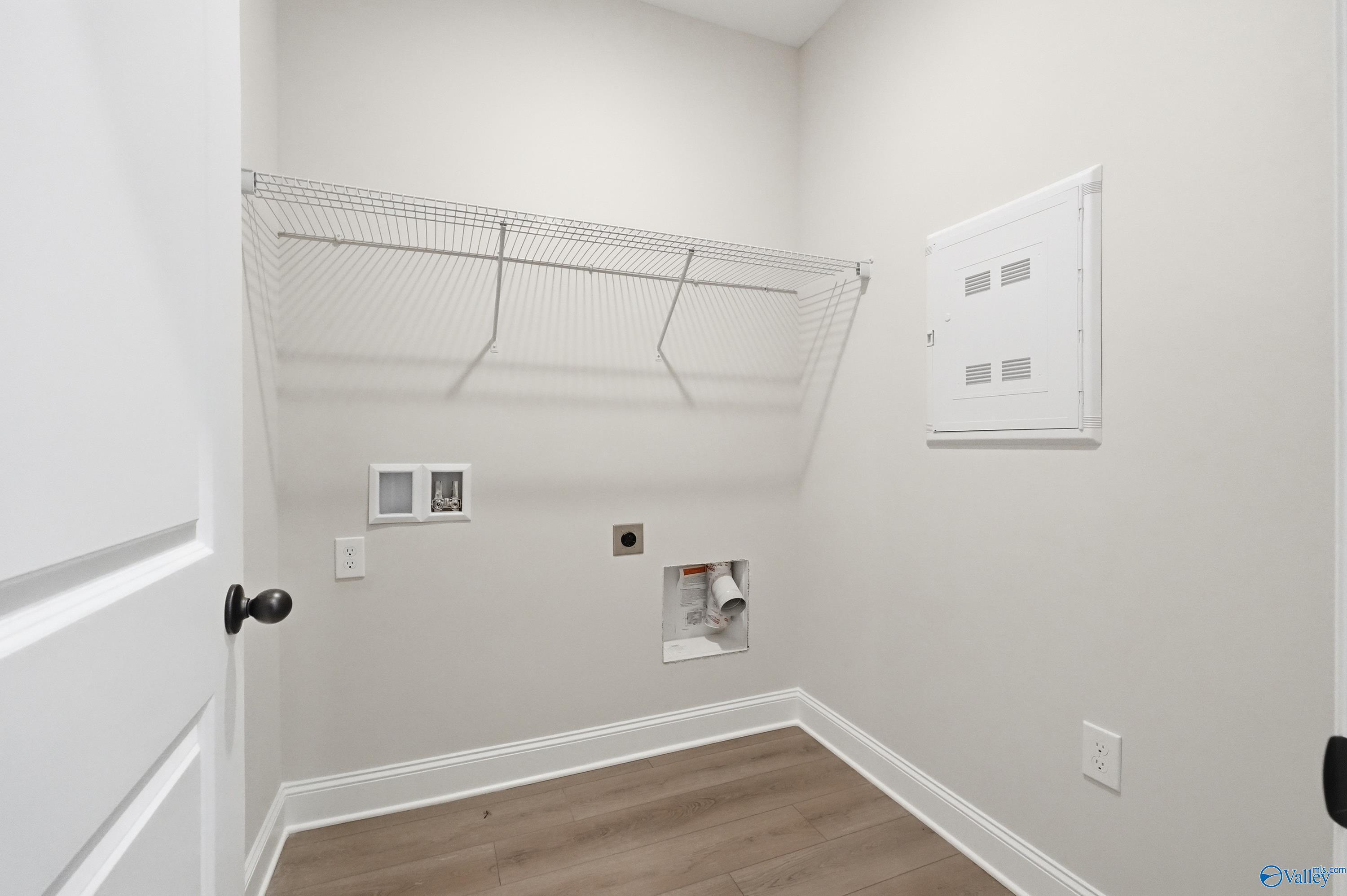 Functional laundry room with wire shelving, washer/dryer hookups, electrical panel in The Franklin home, Huntsville, Alabama