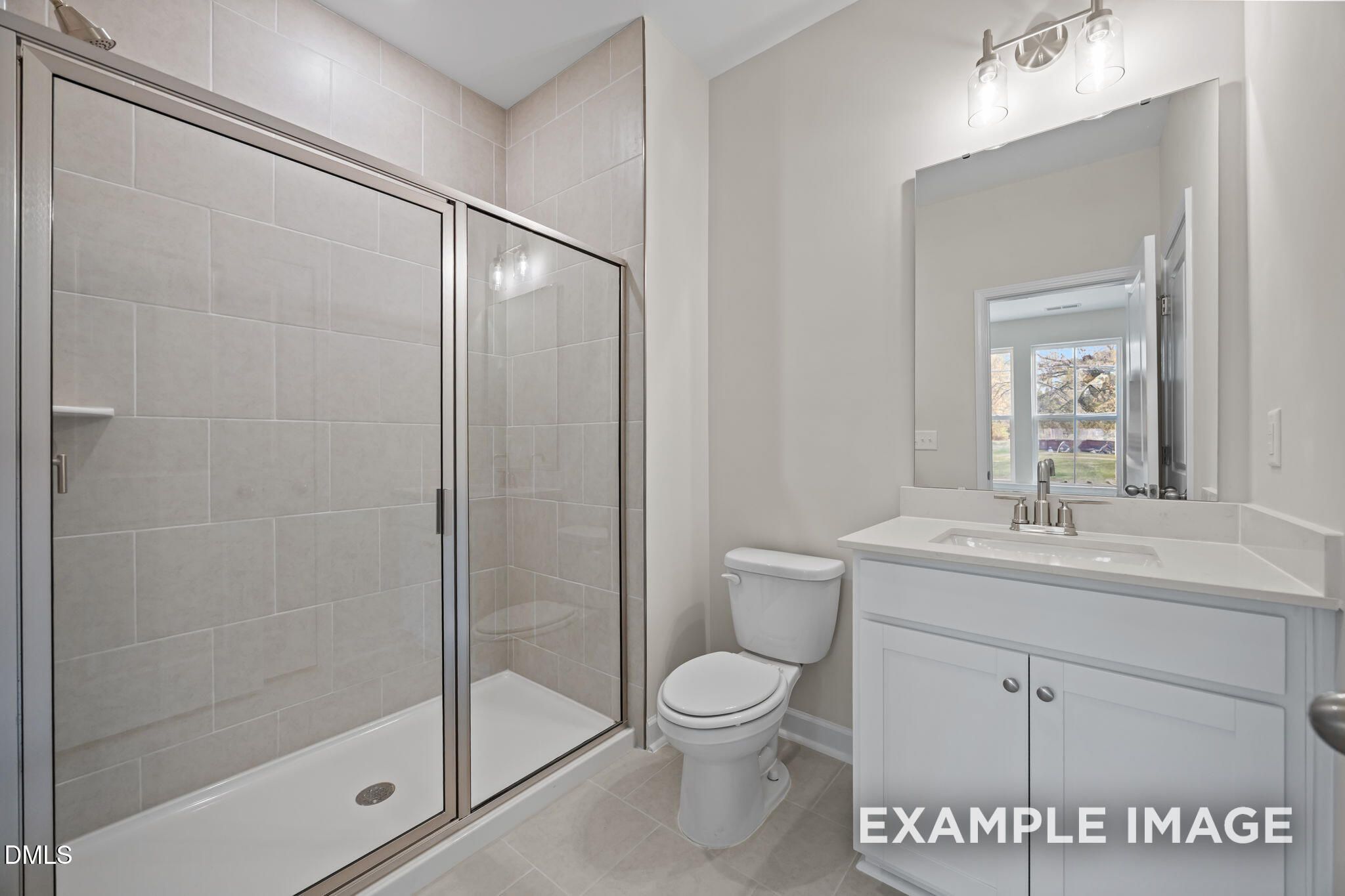 Elegant bathroom with glass shower enclosure, white vanity sink, toilet, and neutral tiles in Davidson Homes The Avery, Knightdale, NC