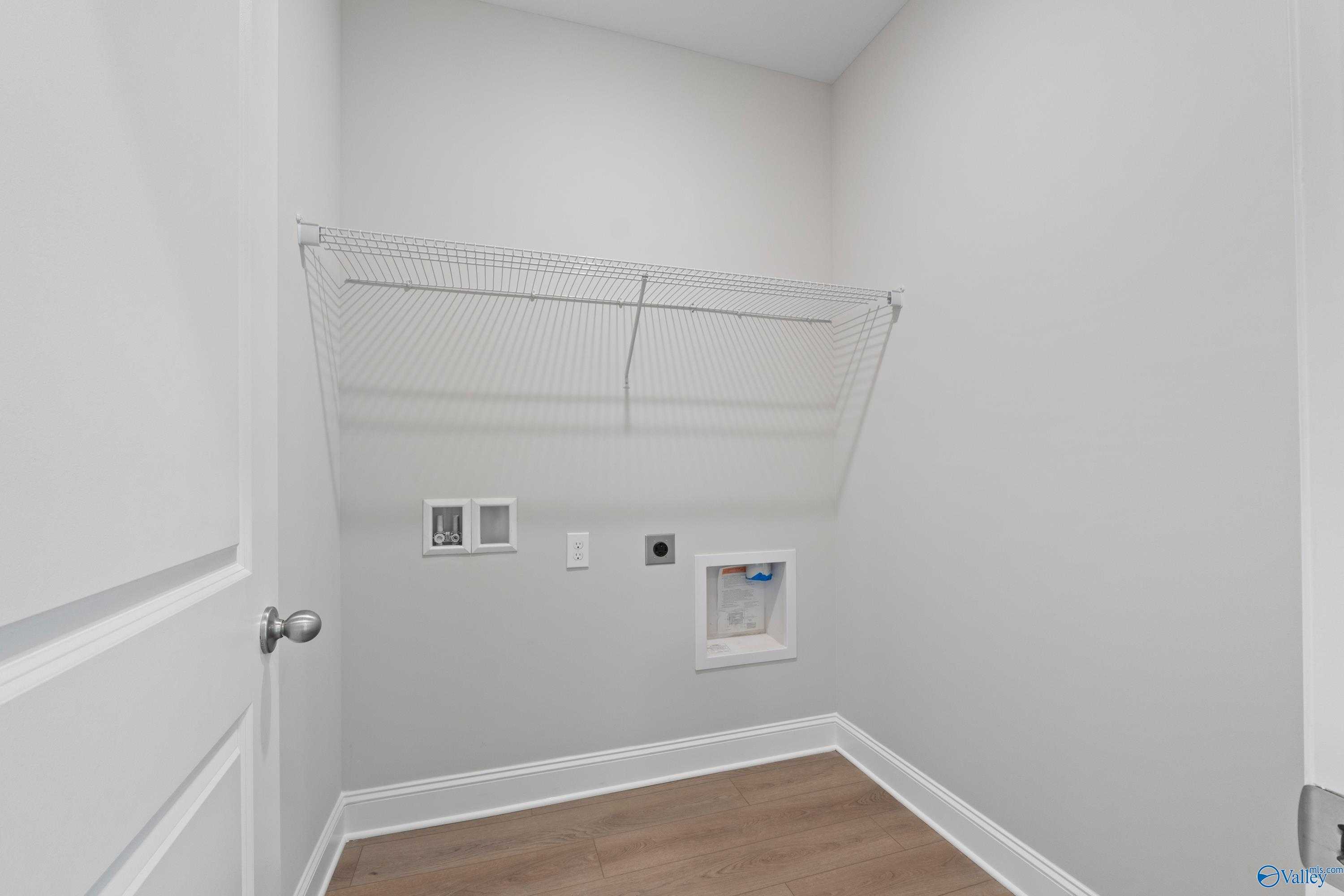 Spacious laundry room with wire shelving and washer-dryer hookups in Davidson Homes The Franklin C, Harvest, Alabama