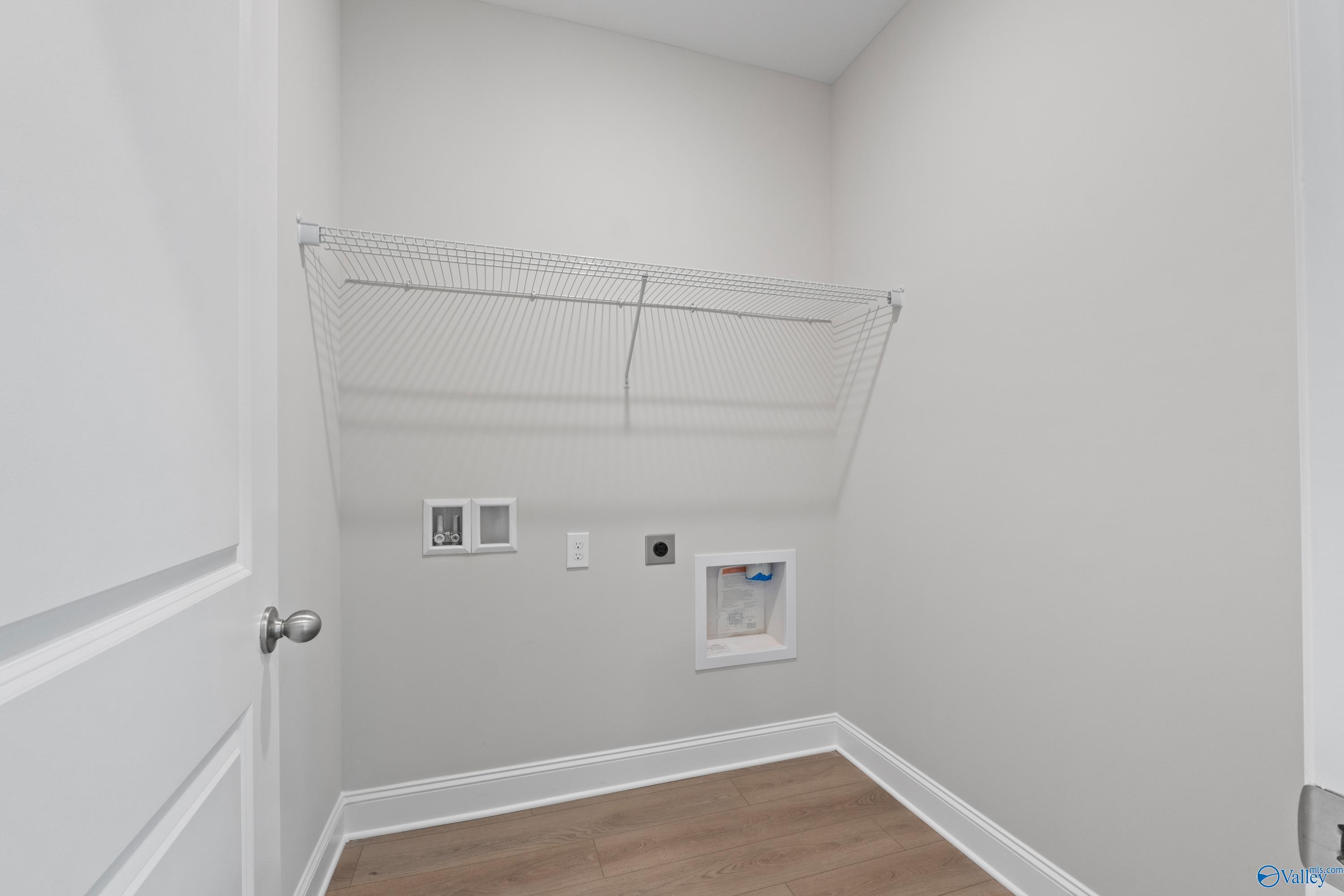 Spacious laundry room with wire shelving and washer-dryer hookups in Davidson Homes The Franklin C, Harvest, Alabama