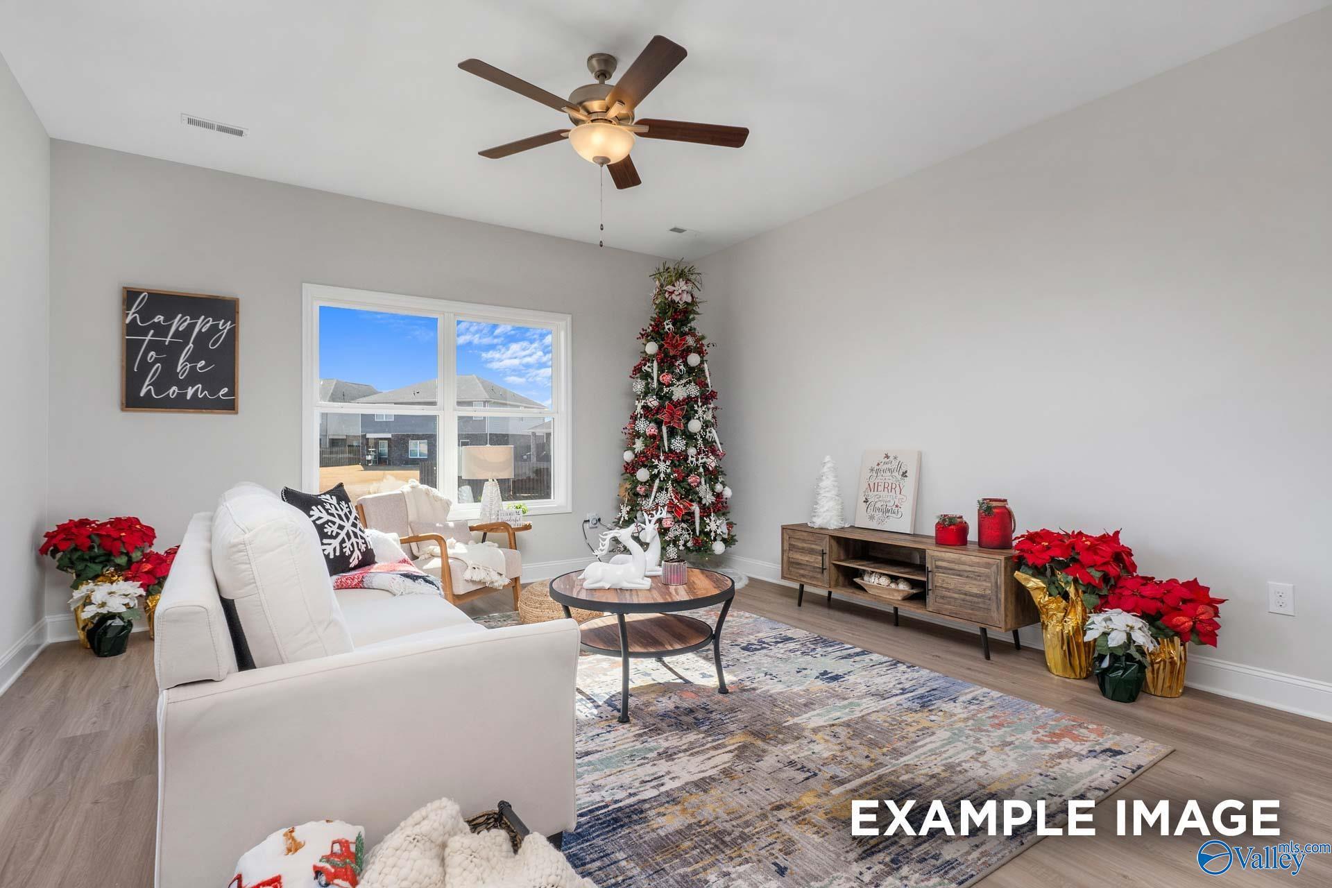 Festive living room with decorated Christmas tree, poinsettias, and cozy white sofa in 4-bedroom Davidson Homes The Daphne D, Meridianville, Alabama