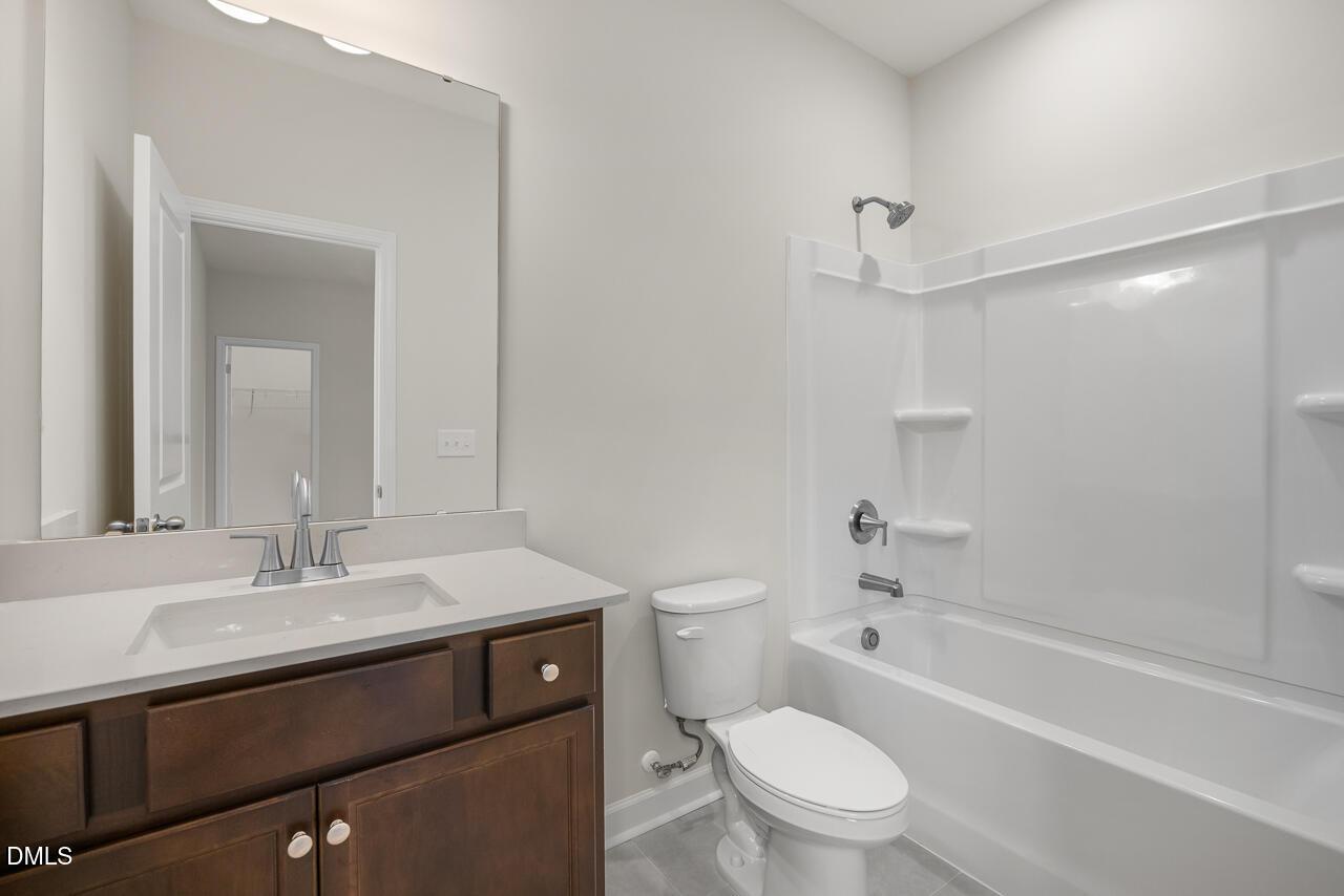 Modern bathroom with vanity, mirror, and tub-shower combo in The Hickory II B plan by Davidson Homes, Aberdeen, NC.