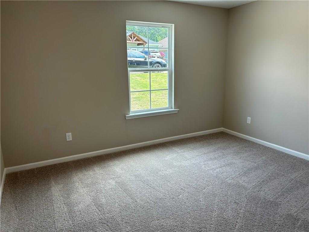 Bright secondary bedroom with large window overlooking green yard in Davidson Homes The Washington, Phenix City, Alabama