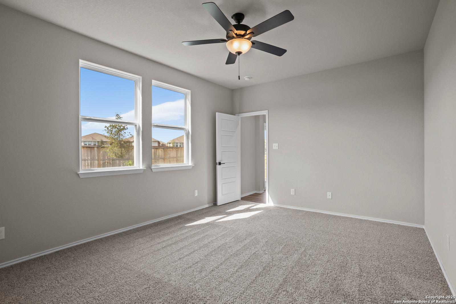 Bright secondary bedroom with gray walls, dual windows, ceiling fan in Davidson Homes The Douglas F, San Antonio