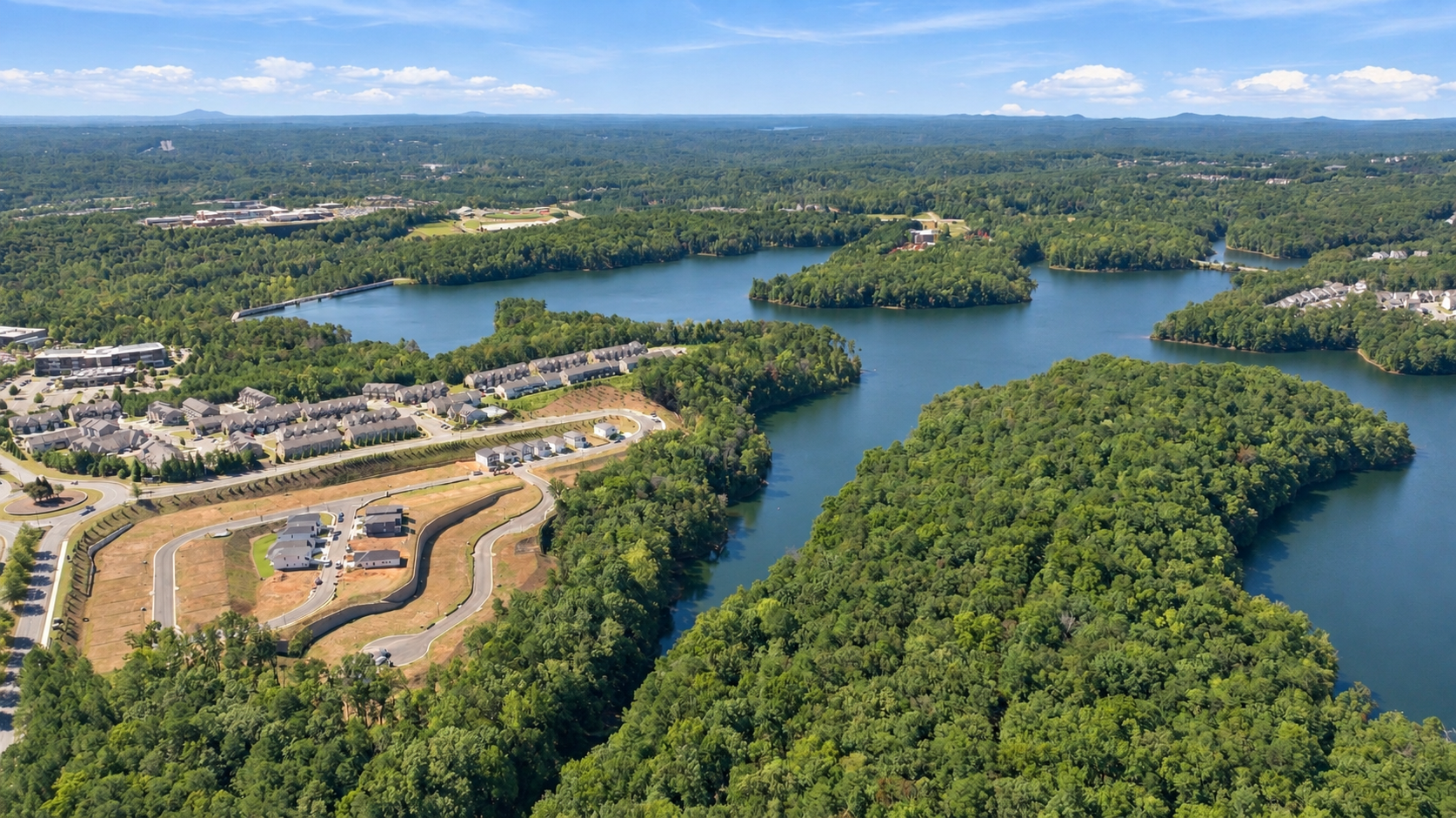 Aerial view of The Bluffs community in Canton, Georgia, featuring Davidson Homes nestled beside scenic lakefront views.