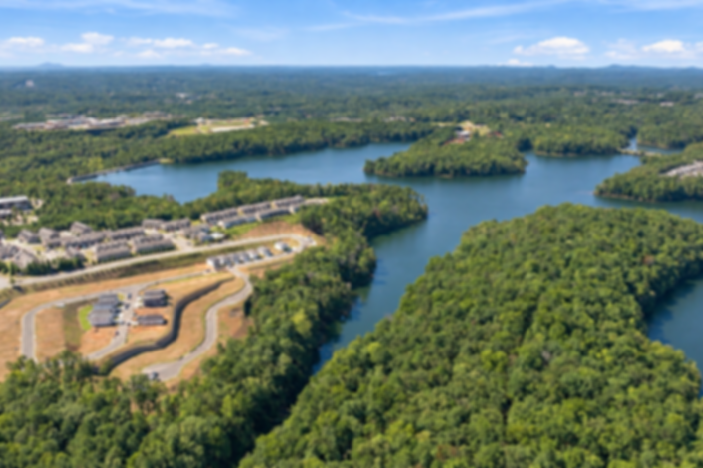 Aerial view of The Bluffs community in Canton, Georgia by Davidson Homes, featuring lakefront homesites surrounded by lush trees
