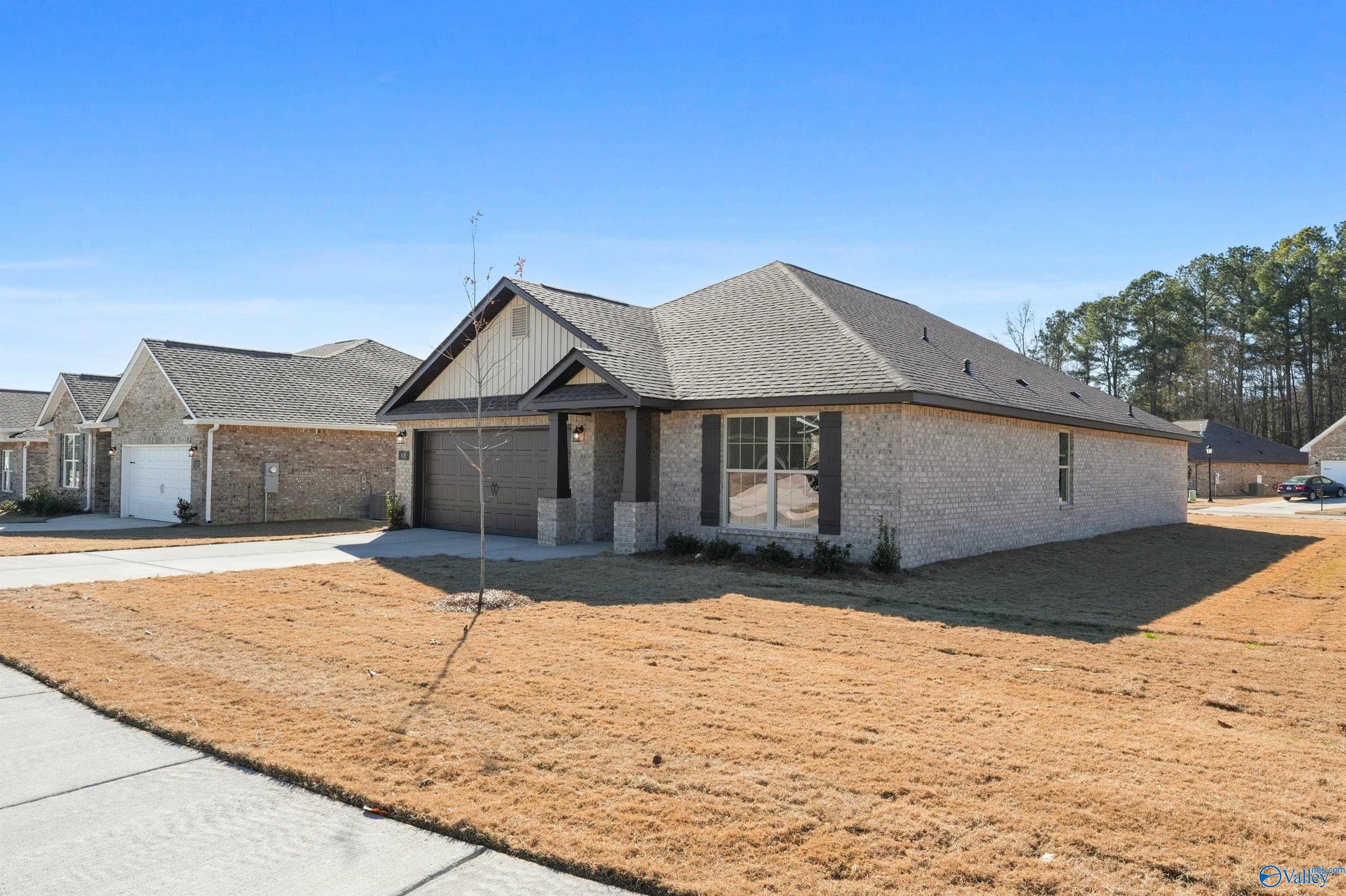 Beige brick single-story home with 2-car garage, shingled roof, and driveway in The Highlands, Arab, Alabama - Davidson Homes Daphne C