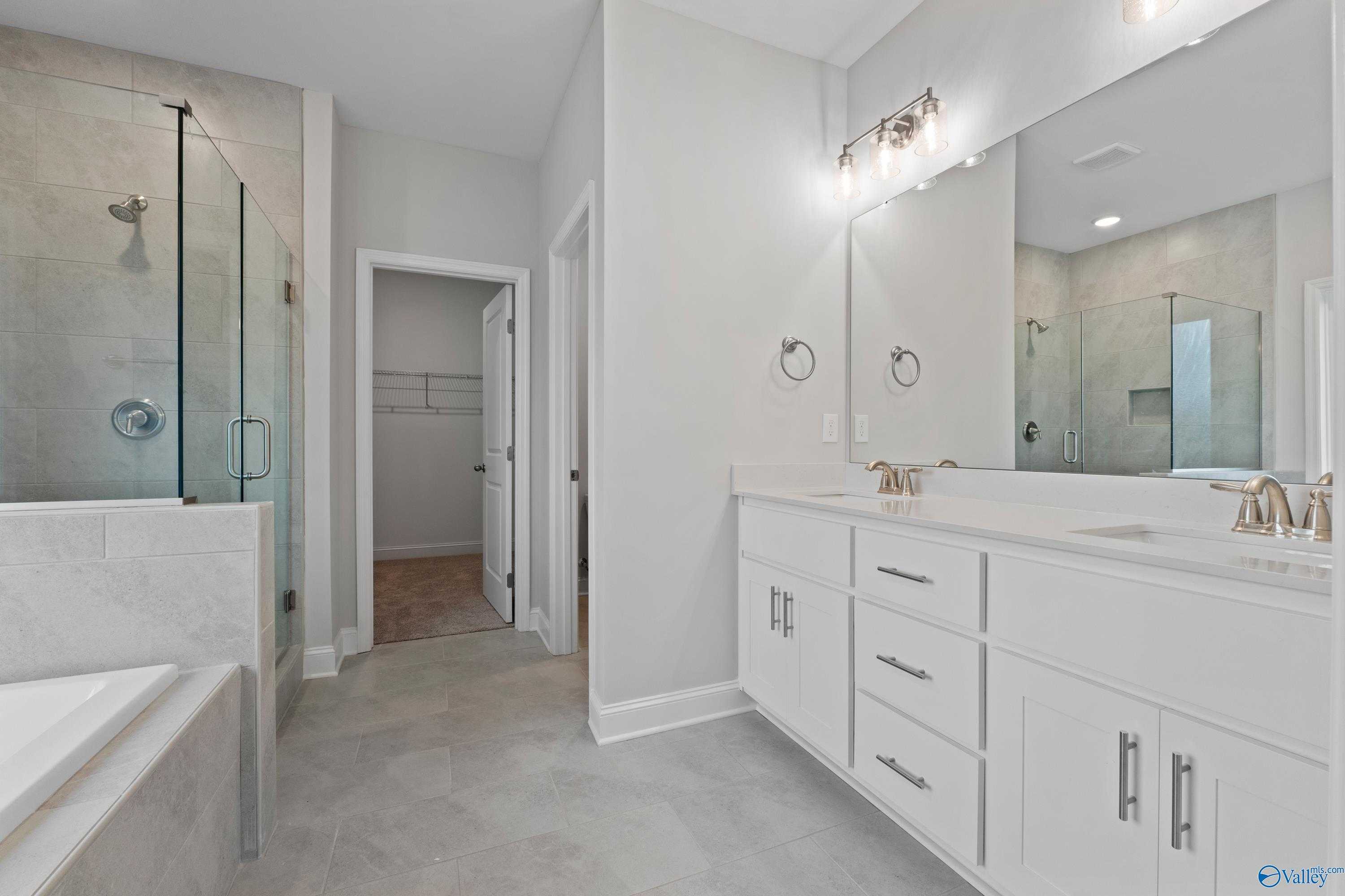 Luxurious master bath with glass shower, freestanding tub, double white vanity in Davidson Homes The Rockford B, Toney, AL