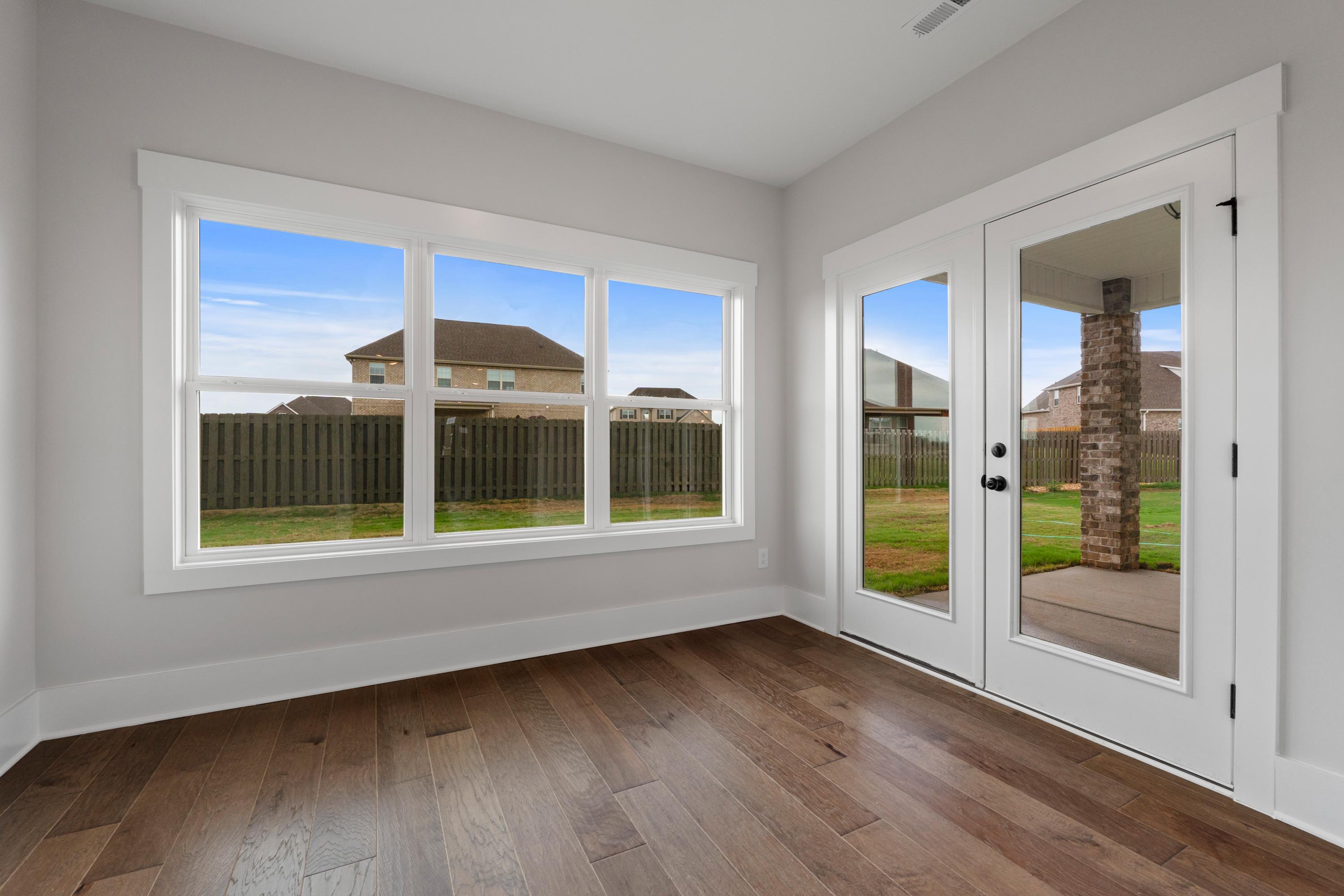 Sunlit study with hardwood floors, large windows, and French doors to patio at The Villas at Barnett's Crossing in Madison, Alabama