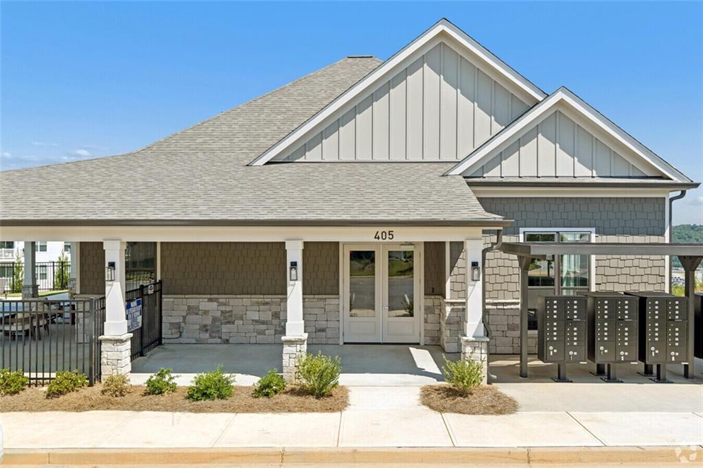 Clubhouse entrance with covered porch, stone accents, and mailbox kiosk at Davidson Homes Stegall Village community in Emerson, Georgia