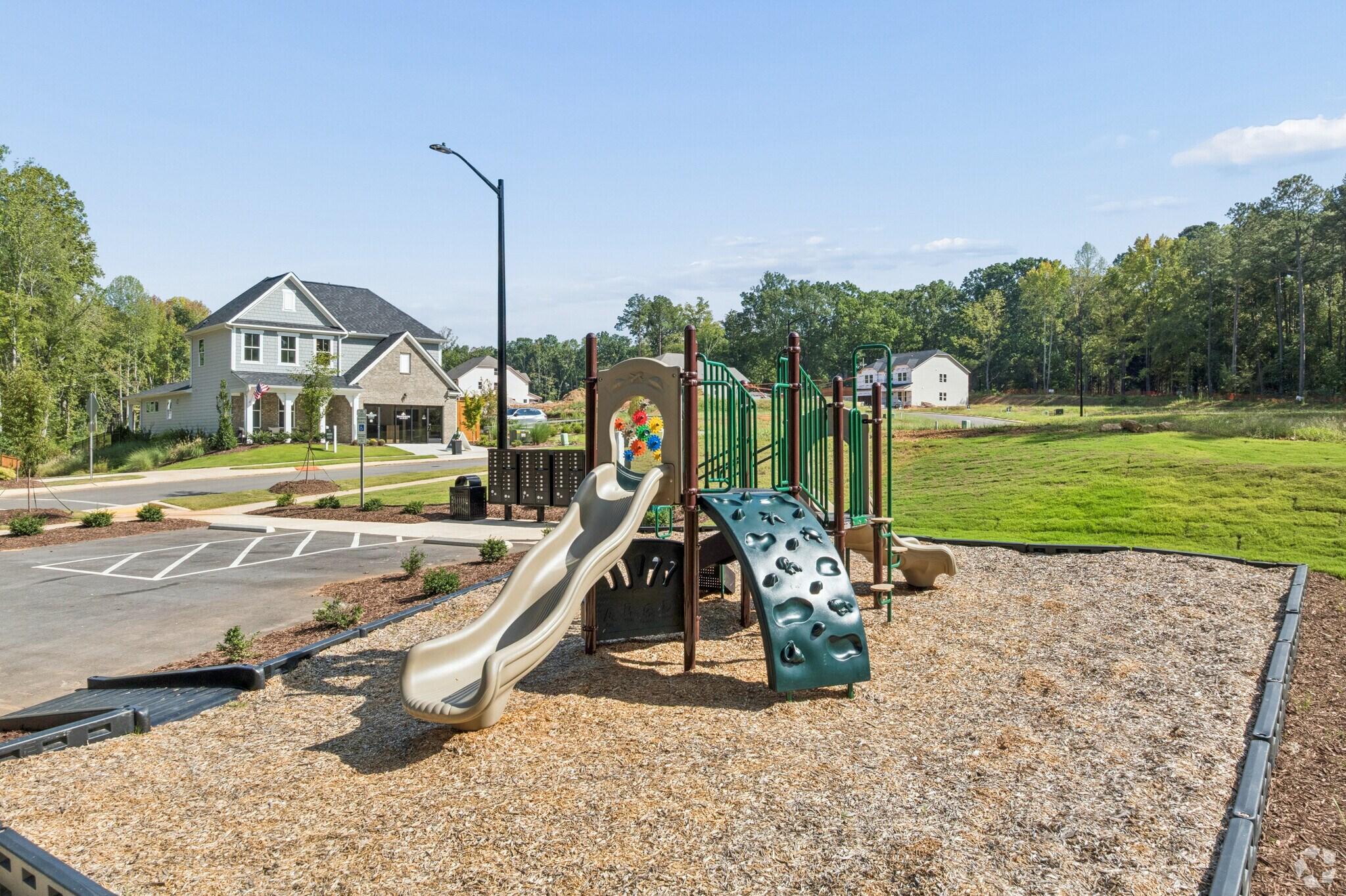 Community playground with slides and climbing wall at Sage on North Main in Wake Forest, NC by Davidson Homes