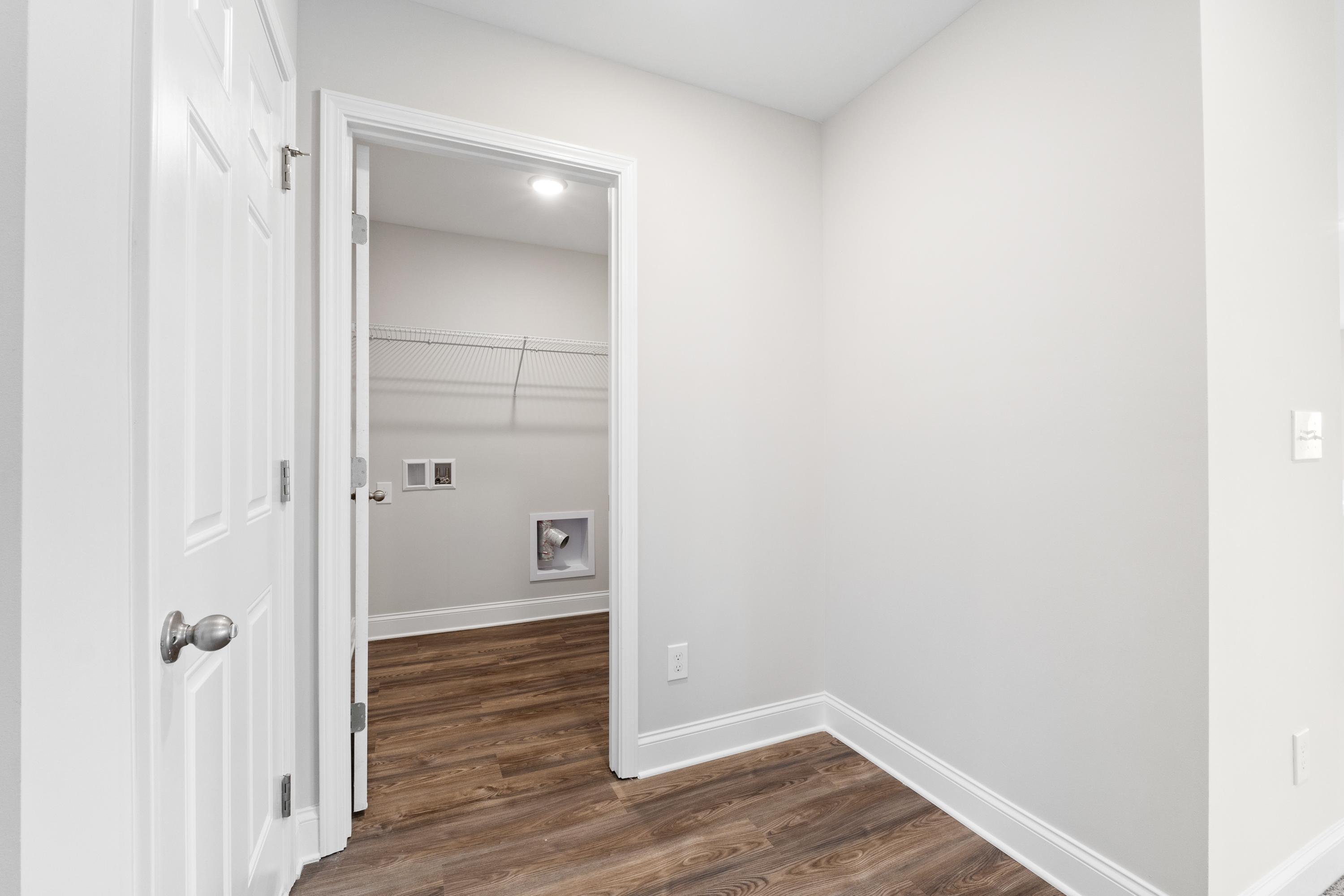 Walk-in laundry closet at Chapel Hill in Athens Alabama with hardwood floors, gray walls, shelving and washer-dryer hookups