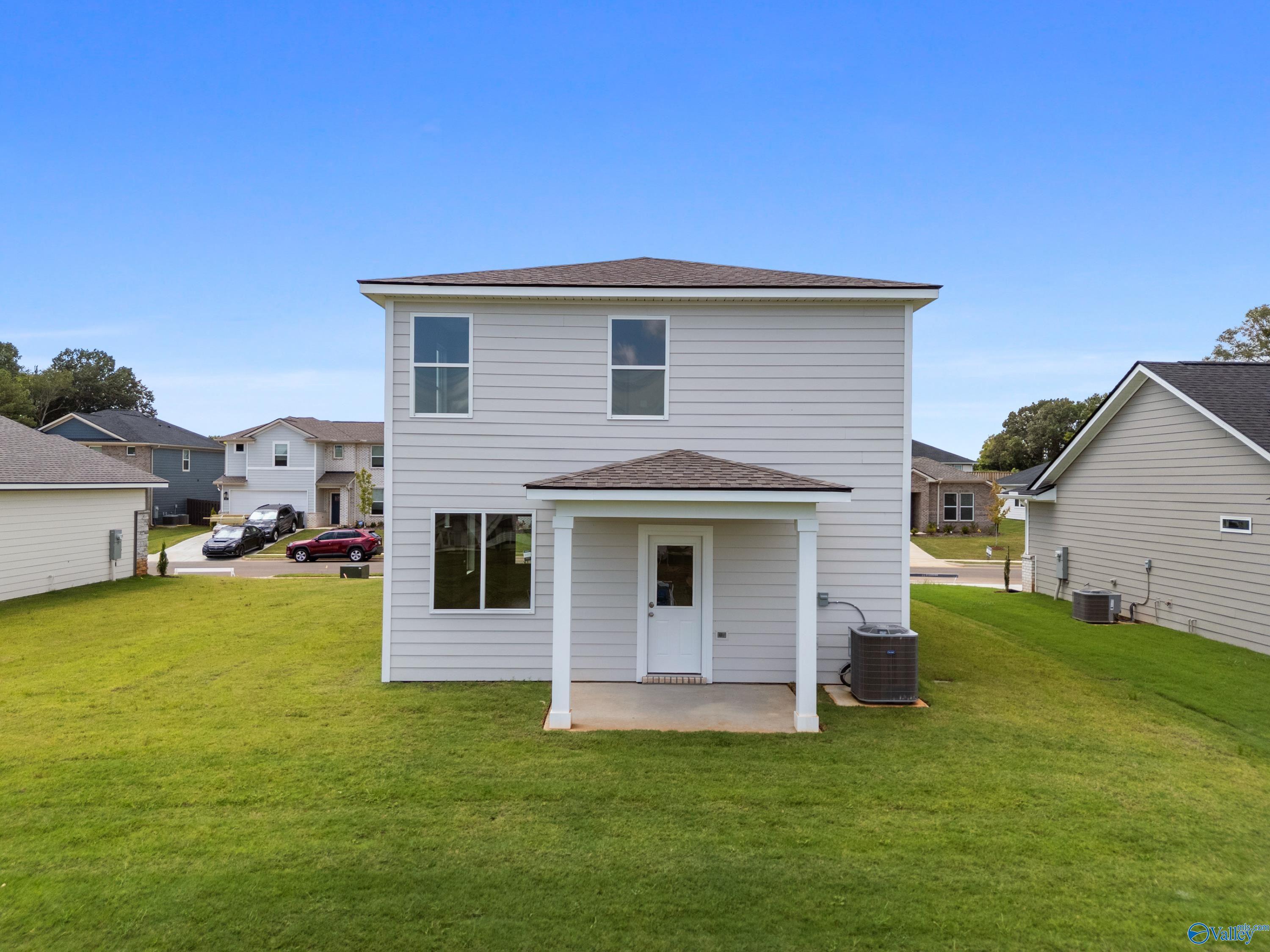 Two-story Augusta floor plan home rear with covered porch, large windows, and lush yard in Evergreen Mill, Madison, Alabama