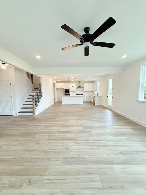 Open-concept living room and modern kitchen in The Hickory B floor plan at Wehunt Meadows, Hoschton, Georgia.
