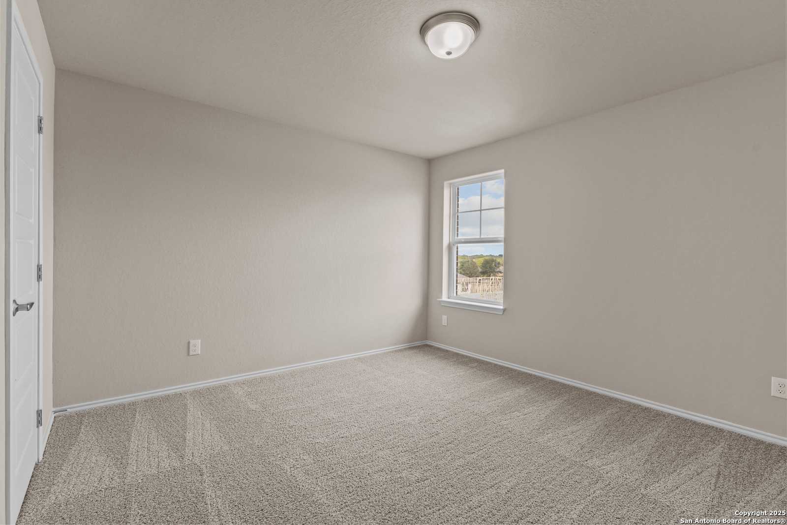 Bright secondary bedroom with beige walls, carpeted floor, and large window in 4-bedroom Davidson Homes The Douglas G, San Antonio